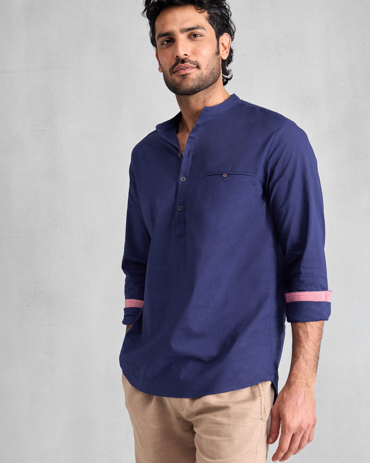 Person wearing an ink blue Pondicherry Shirt with rolled sleeves and pink cuff lining.