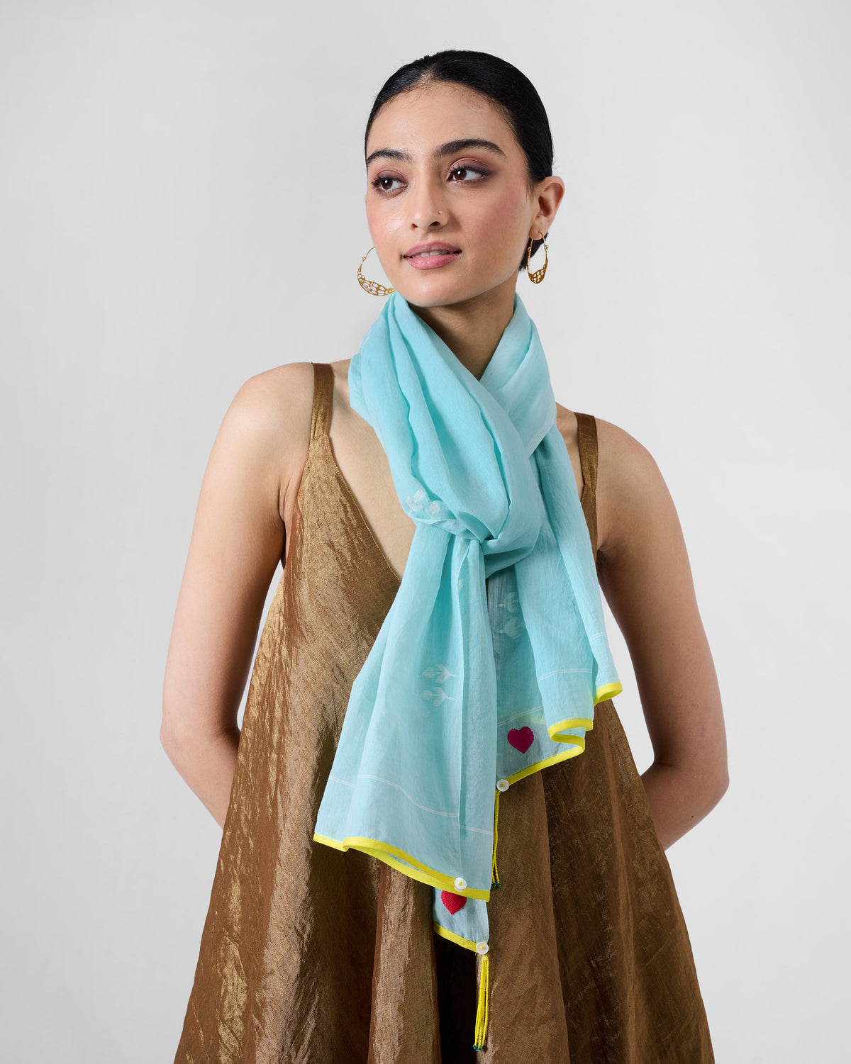 Person wearing a light aqua Sky Jamdani scarf with a yellow edge.