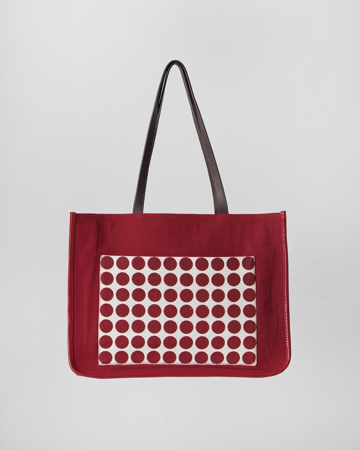 Red Ganges tote with an ivory polka-dot front pocket.
