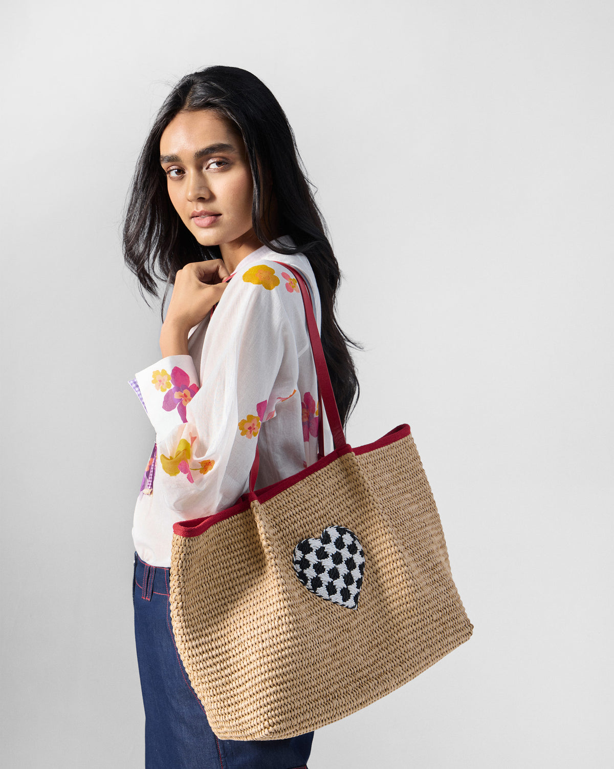 Natural Dil Woven Tote with a checkered heart worn on the shoulder.