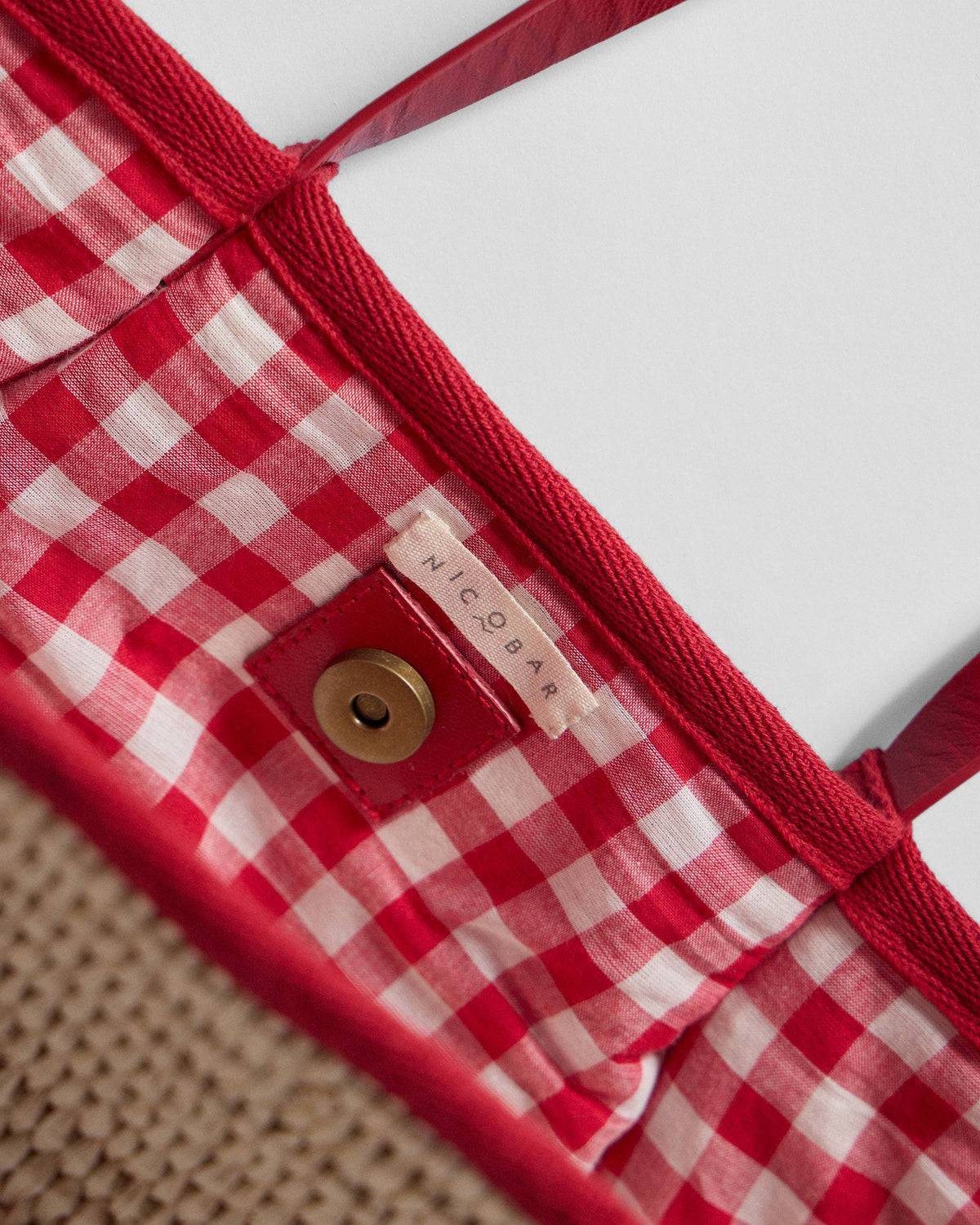 Close-up of the Dil Woven Tote showing red check lining.