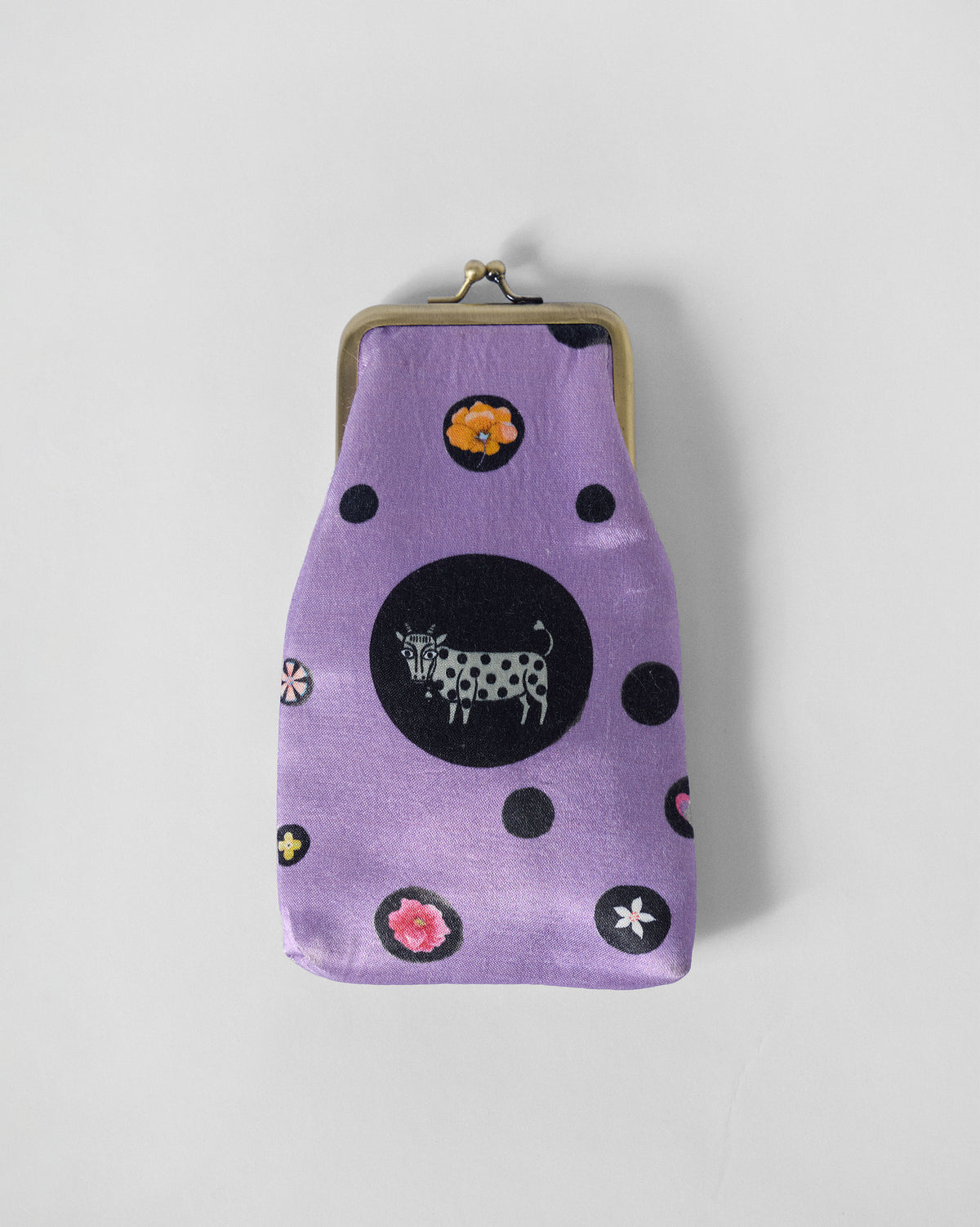 Lilac Hana Spec Case with a black cow motif and small flowers.