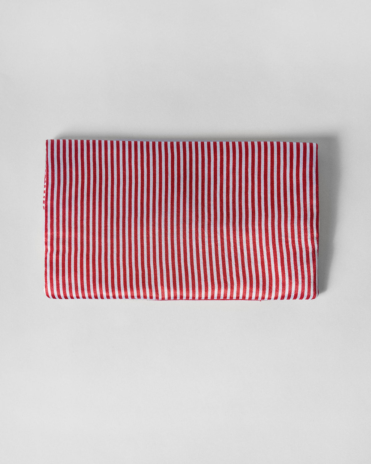 Fold Over Clutch in red and ivory stripes, closed and laid flat.