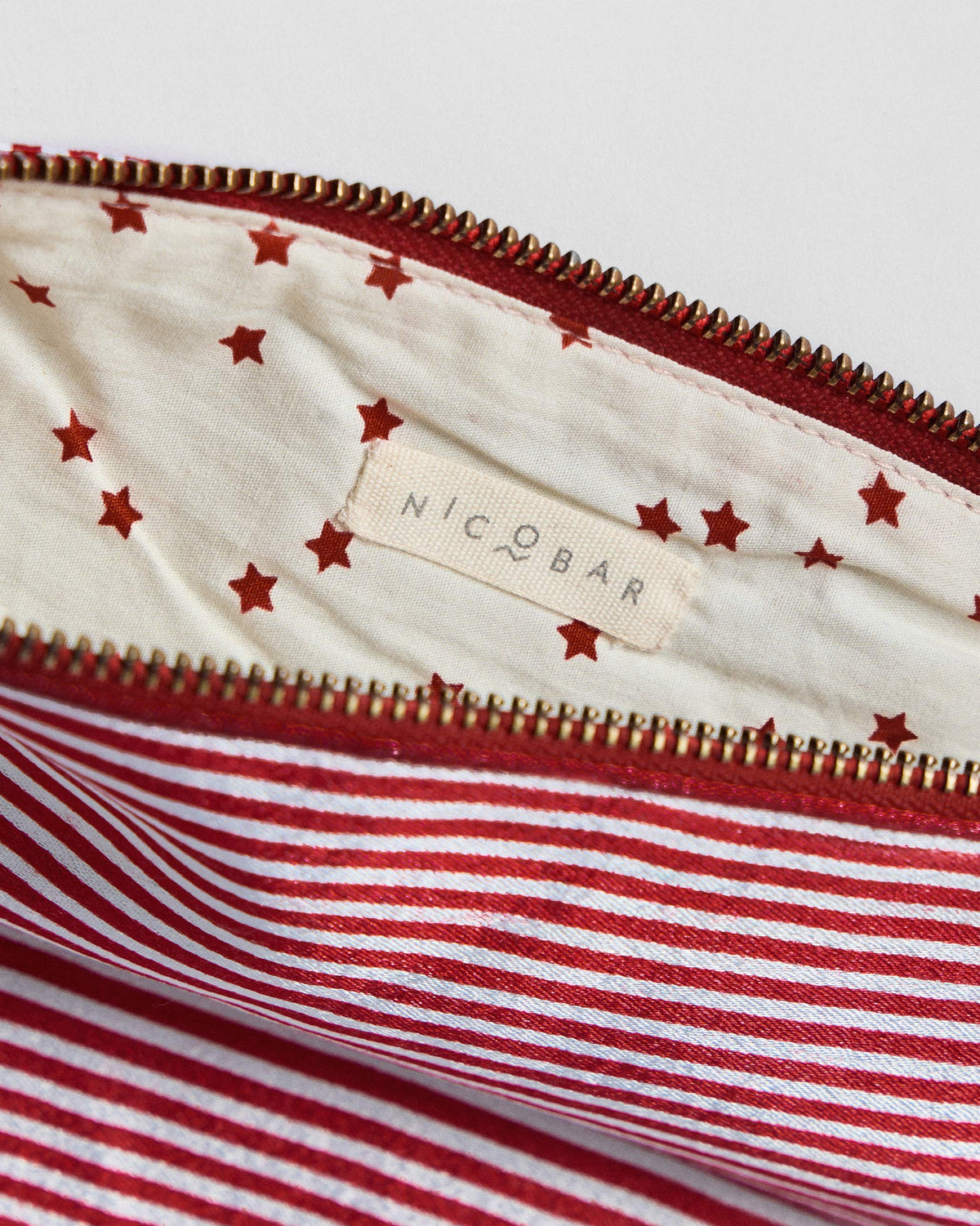 Close-up of the Fold Over Clutch's star-print lining and Nicobar label.