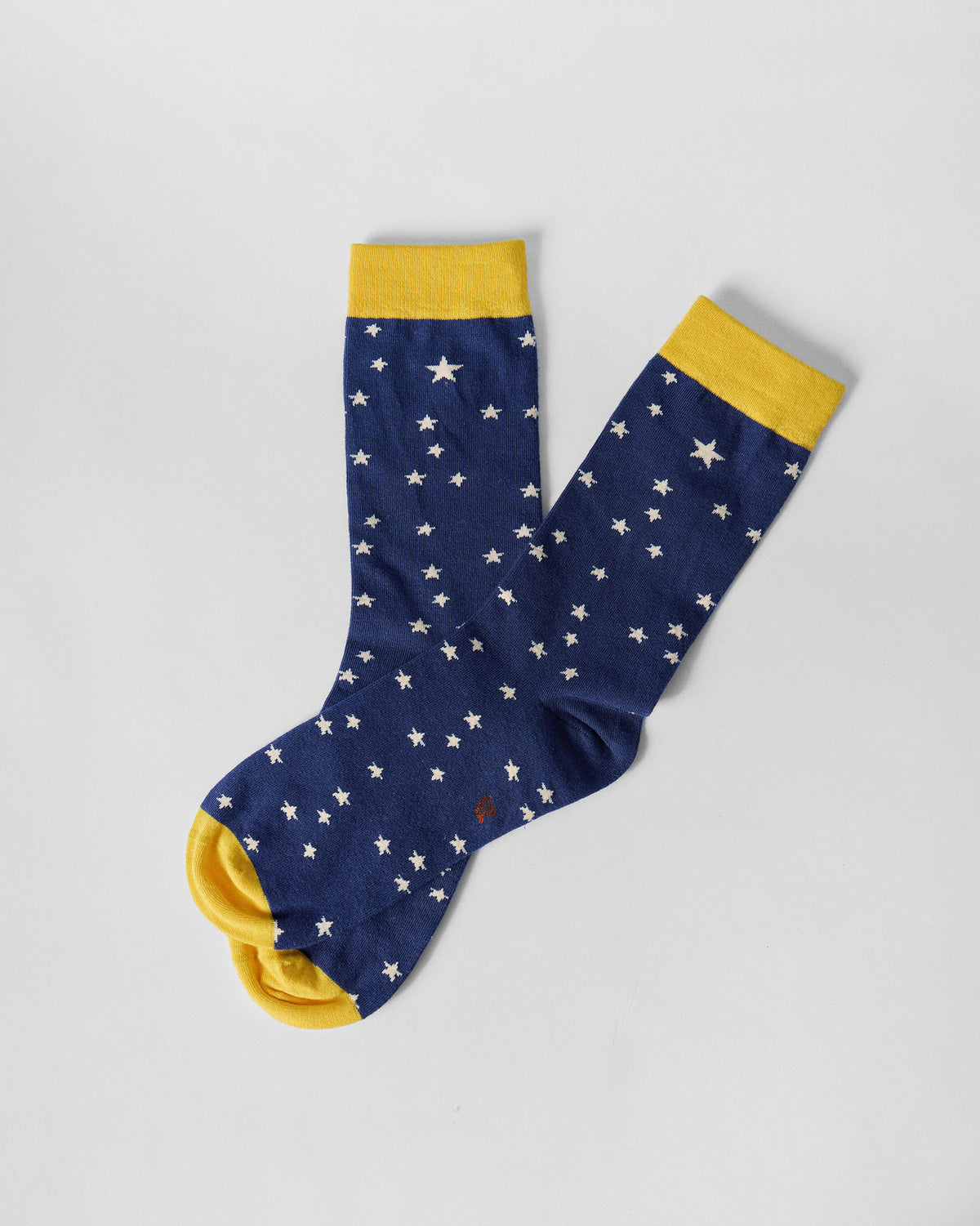 Starry socks laid flat at an angle, showing navy stars and yellow toes.