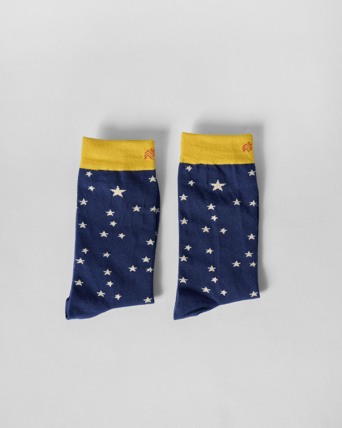Pair of Starry socks laid with cuffs up, showing white stars on navy.