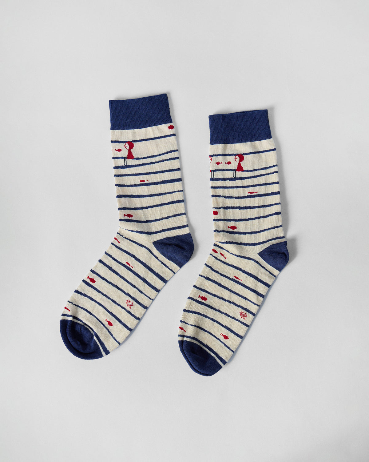 Pair of Go Fish socks laid flat, with navy stripes and red fish motifs.