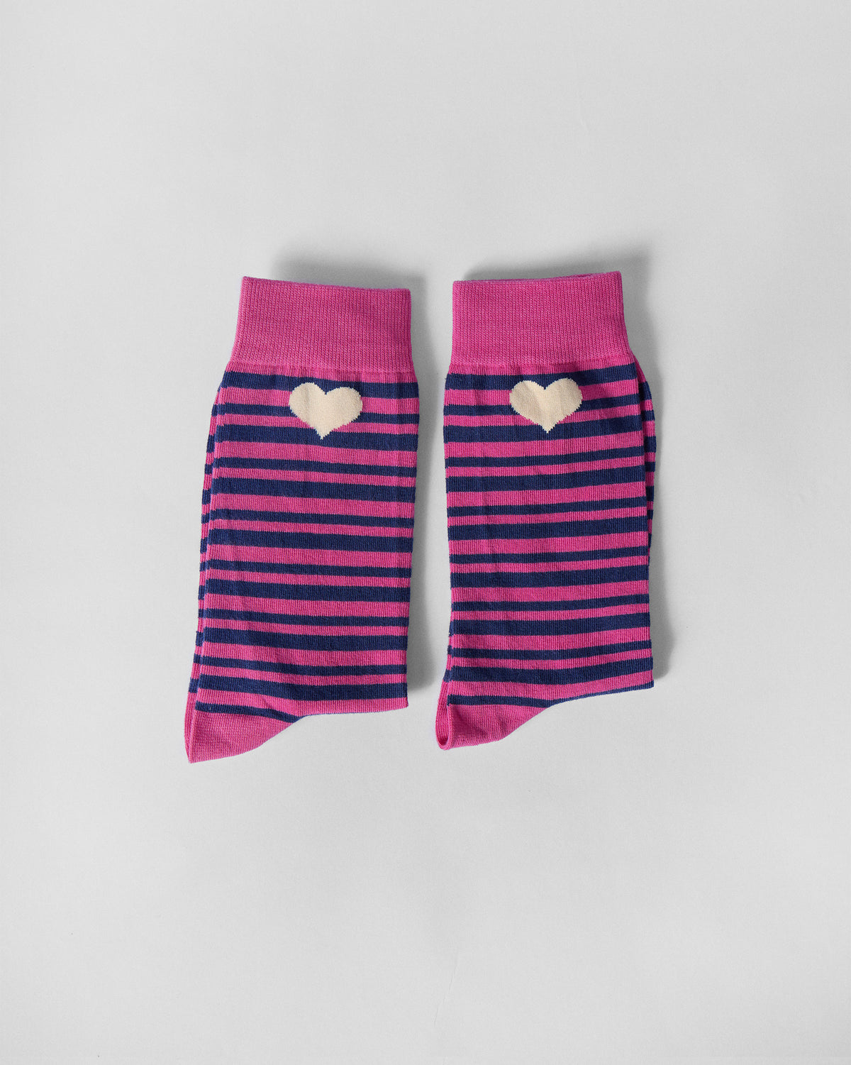 Pair of Thick & Thin socks laid with cuffs up, showing cream hearts on stripes.