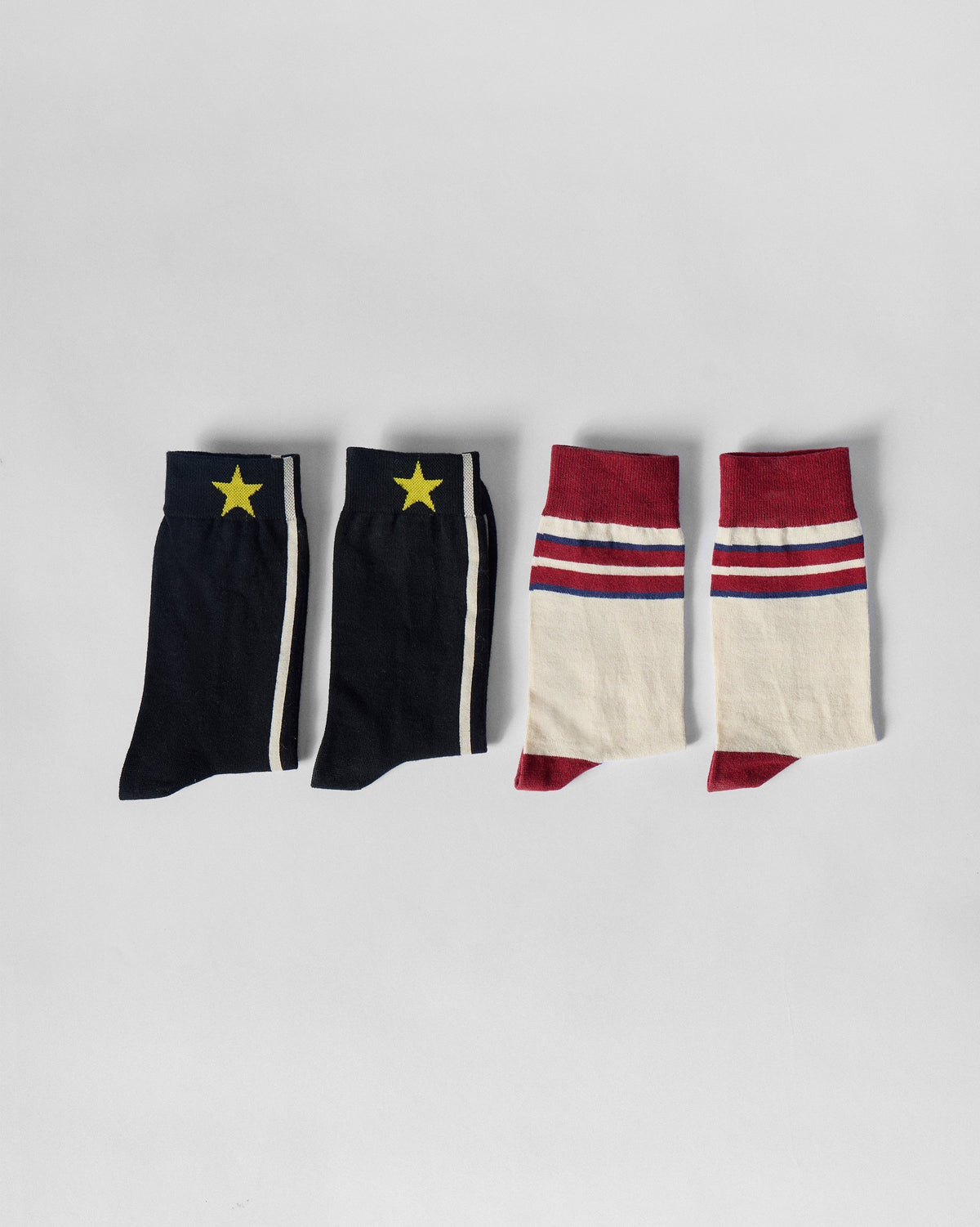 Side view of Men's Orbit Socks in black and cream maroon pairs.
