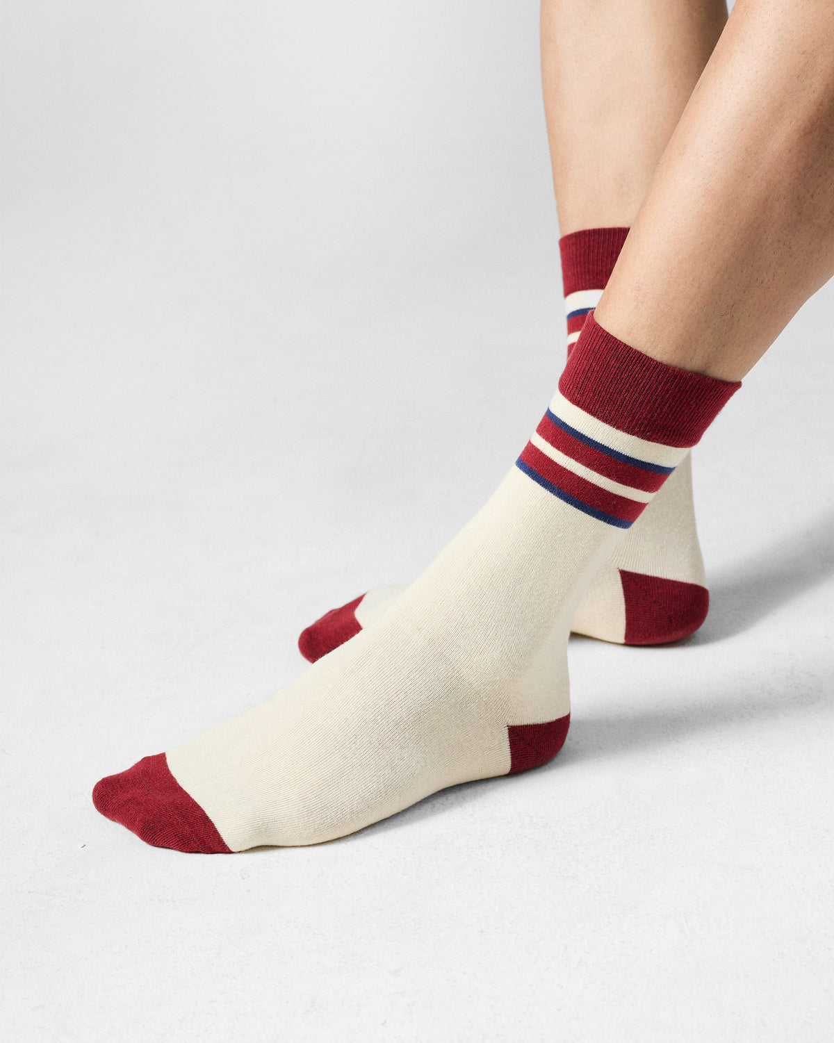 Cream Men's Orbit Socks with maroon accents worn on the feet.