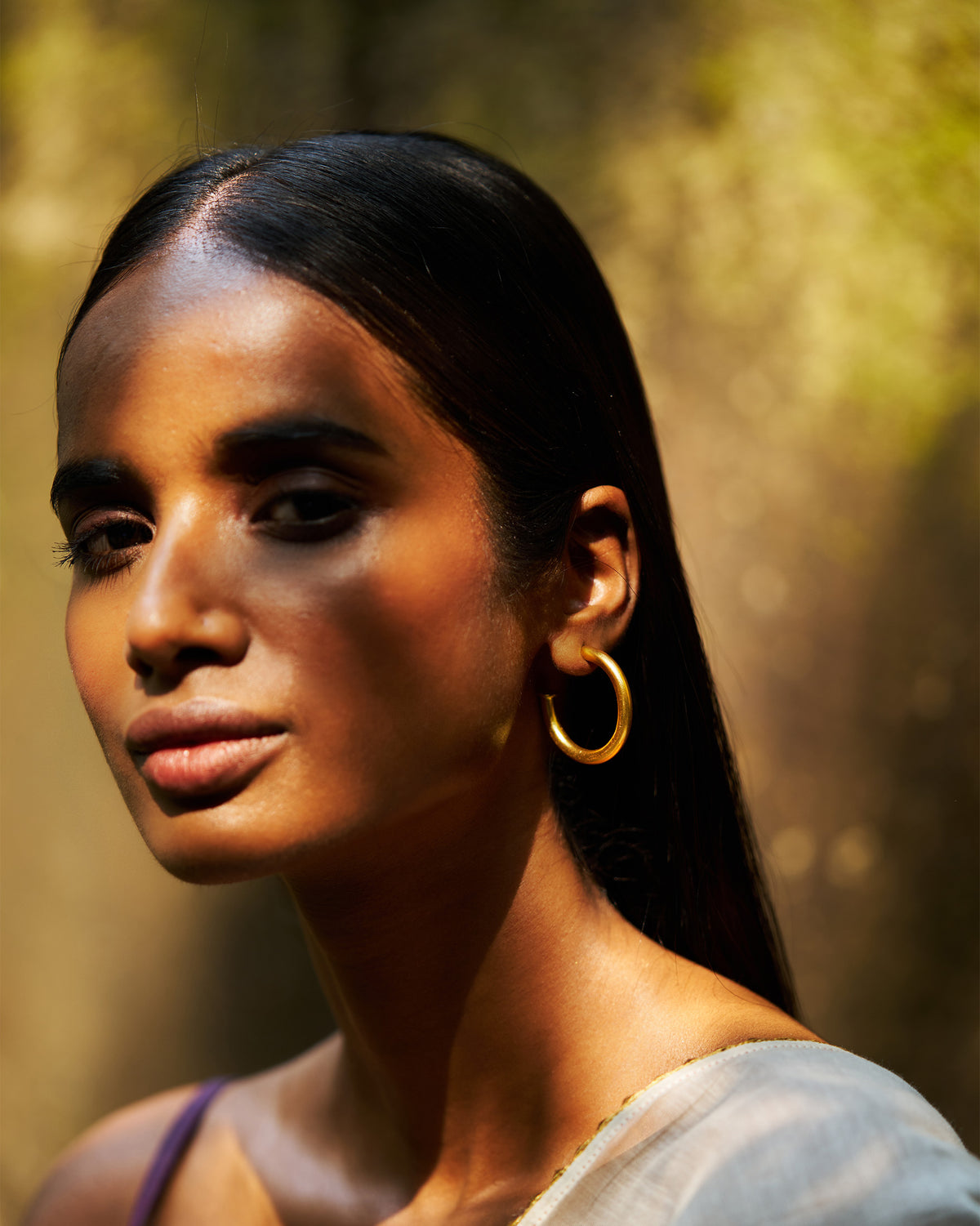 Person wearing gold Everyday Hoops.