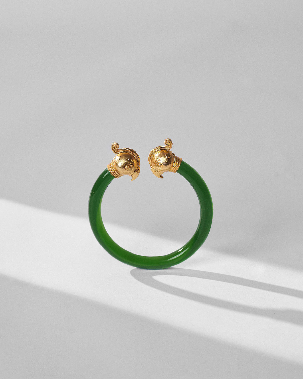 Green Mithu bangle showing gold parrot-head finials.