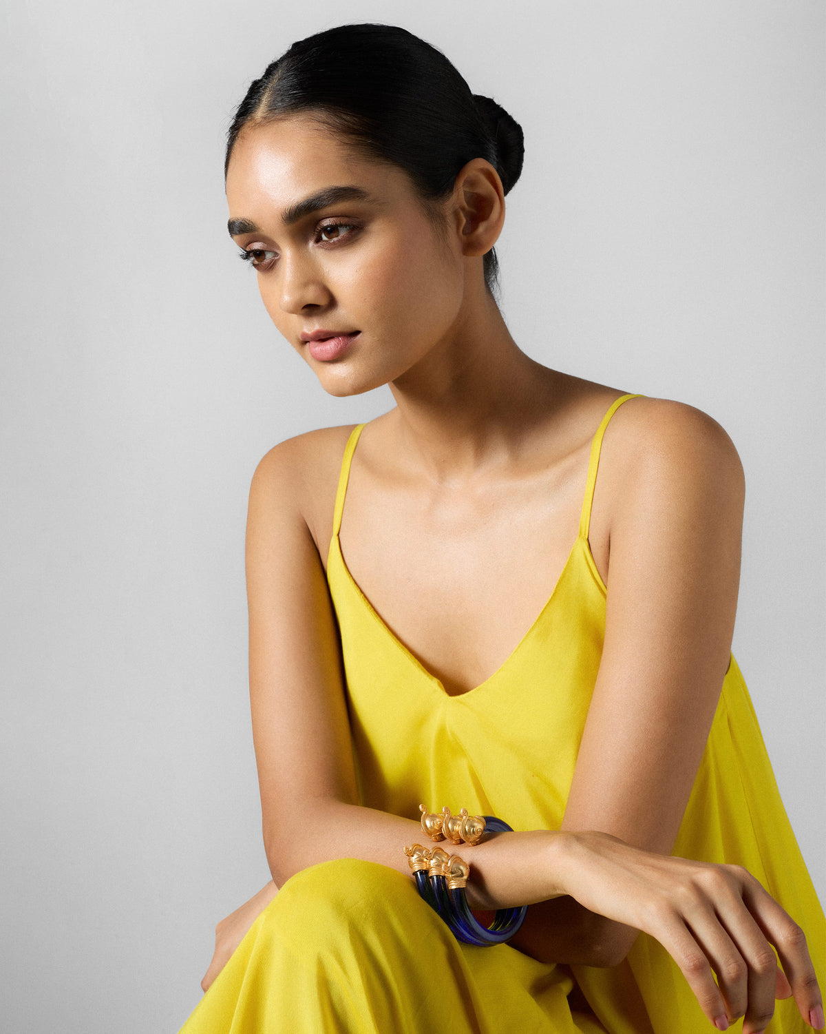 Person wearing stacked blue Mithu Bangles with gold ends.
