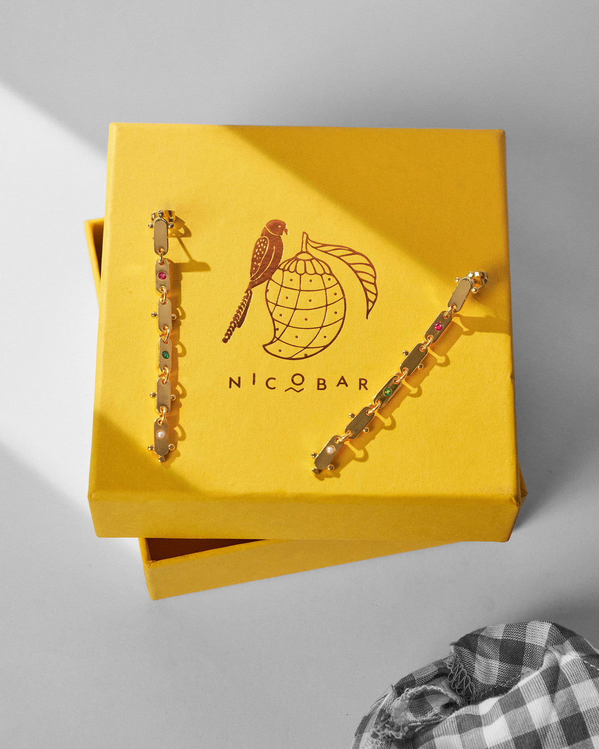 Gold Ladder earrings on a yellow Nicobar gift box.