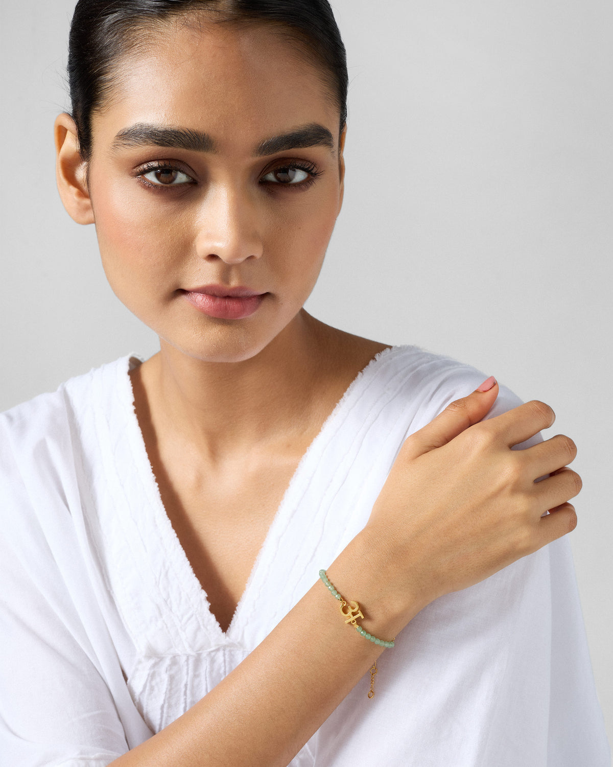 Person wearing Akshar Bracelet (A) - Gold on the arm.