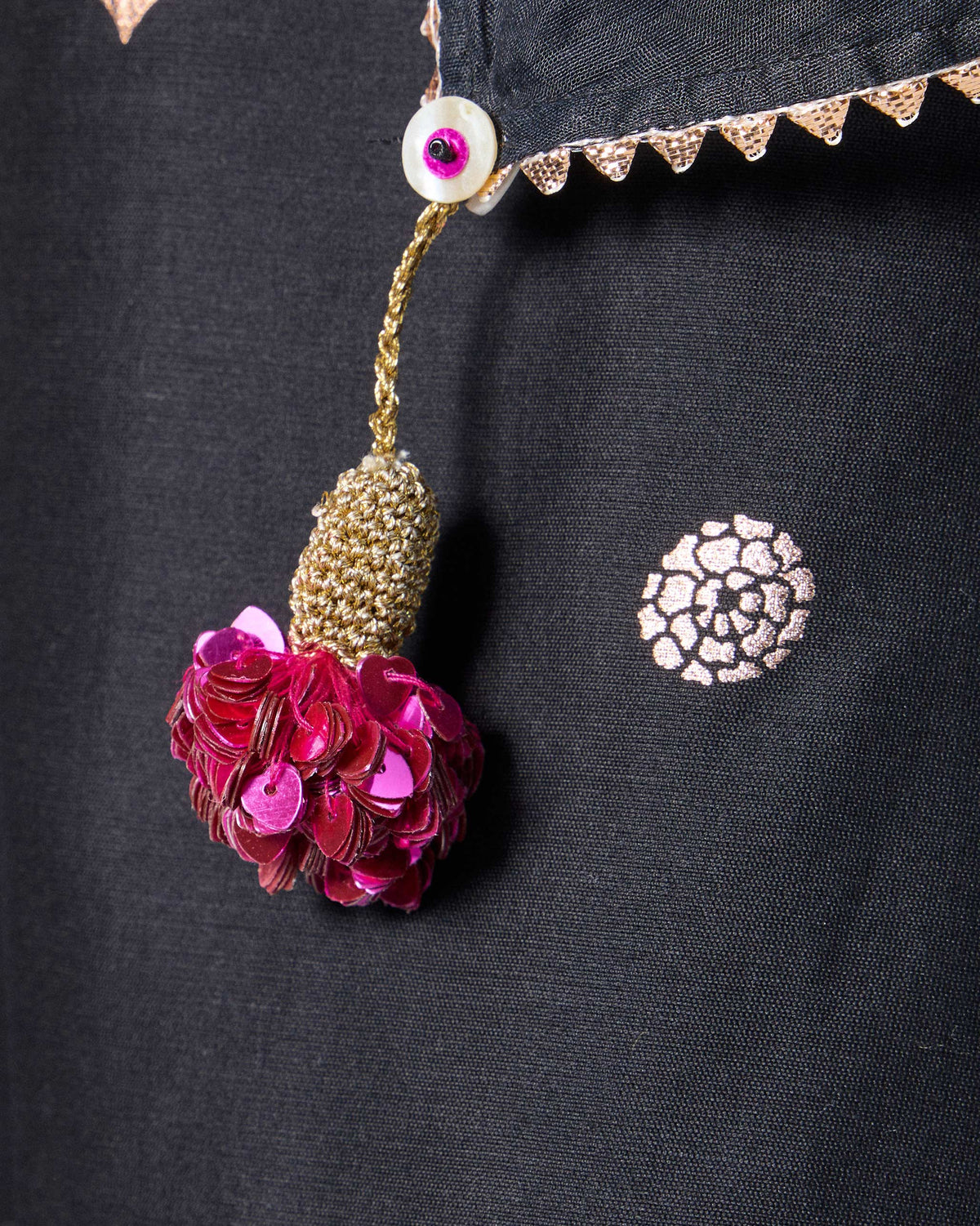 Mala dupatta hung flat with copper floral motifs and tassels at the corners.