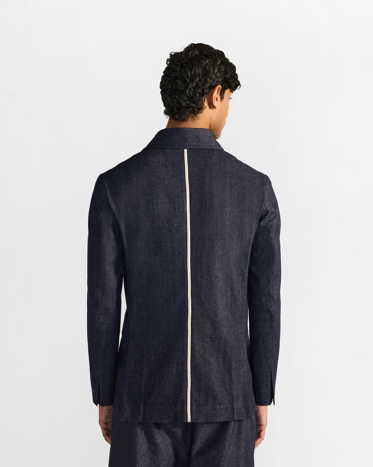 Back of an indigo denim Ibex travel jacket with a cream center stripe.