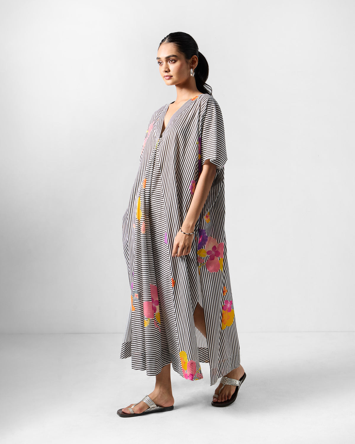 Side view of a Noa kaftan showing a deep side slit and florals.
