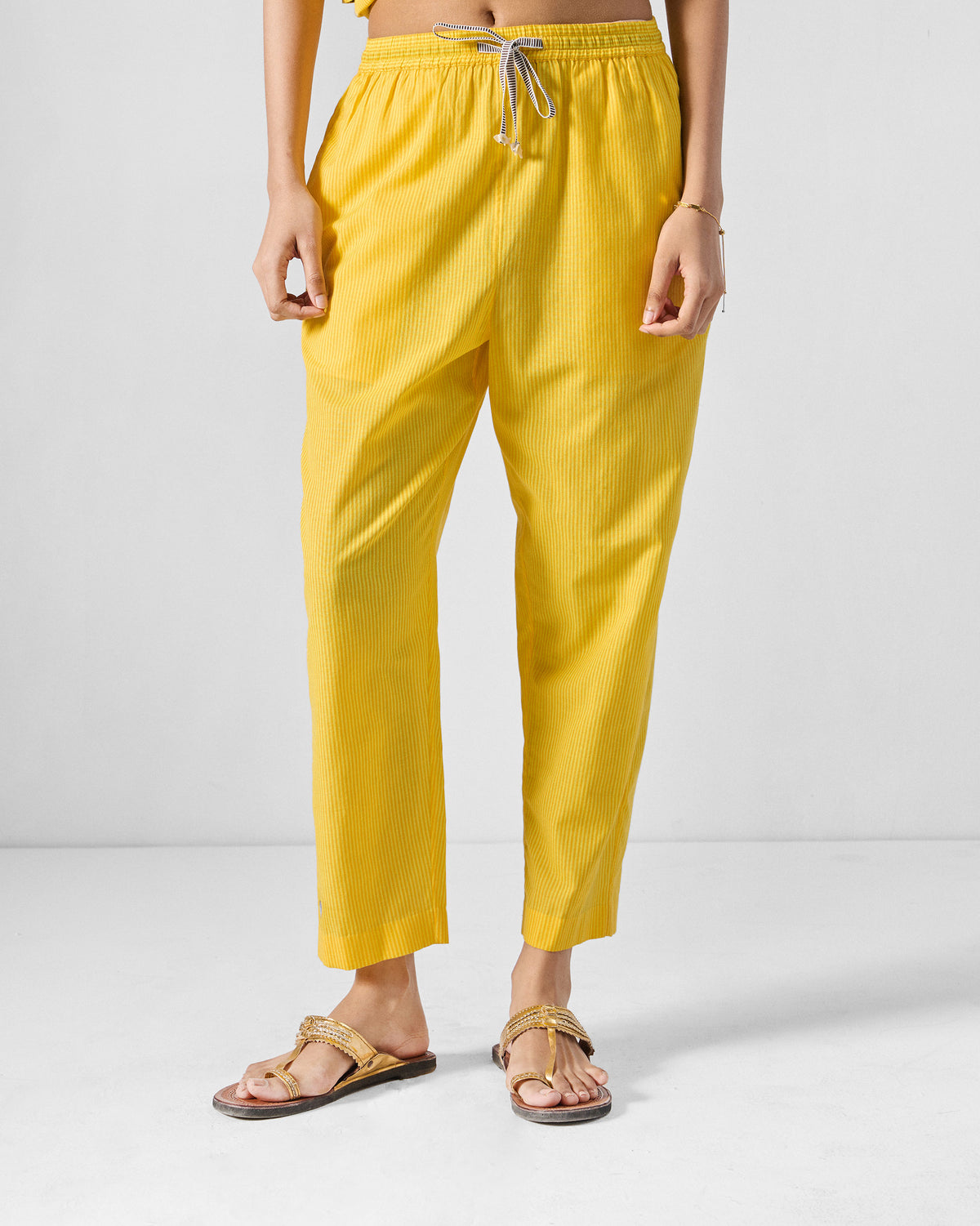 Yellow striped Arzoie pants with an elastic drawstring waist and tapered crop.