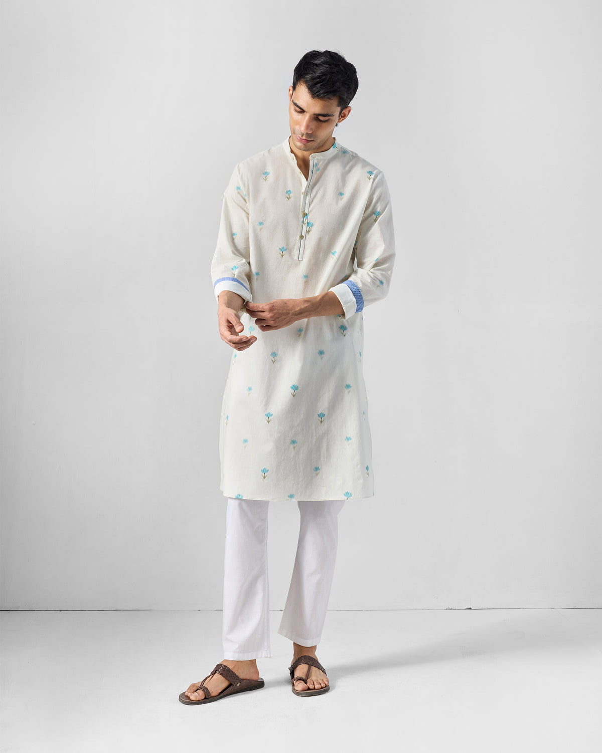 Person wearing an ivory Astral kurta with light blue lotus print.