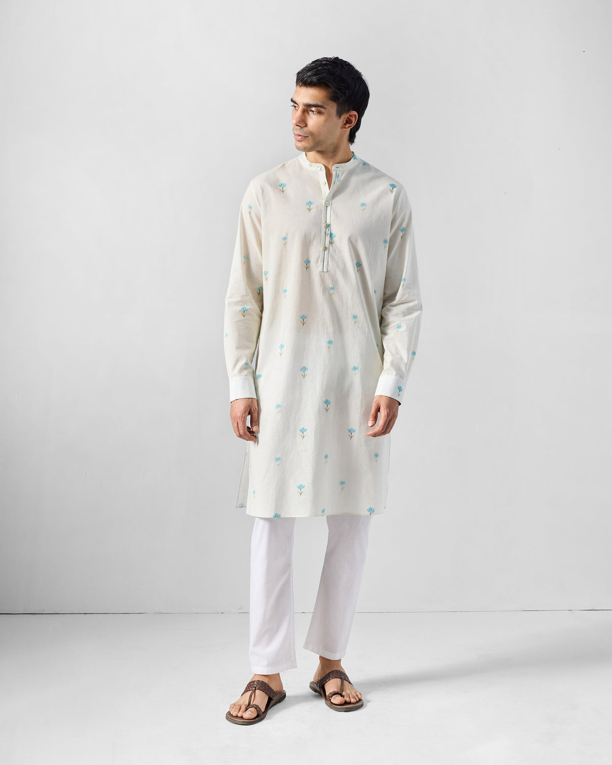 Person wearing an ivory Astral kurta with light blue lotus print.