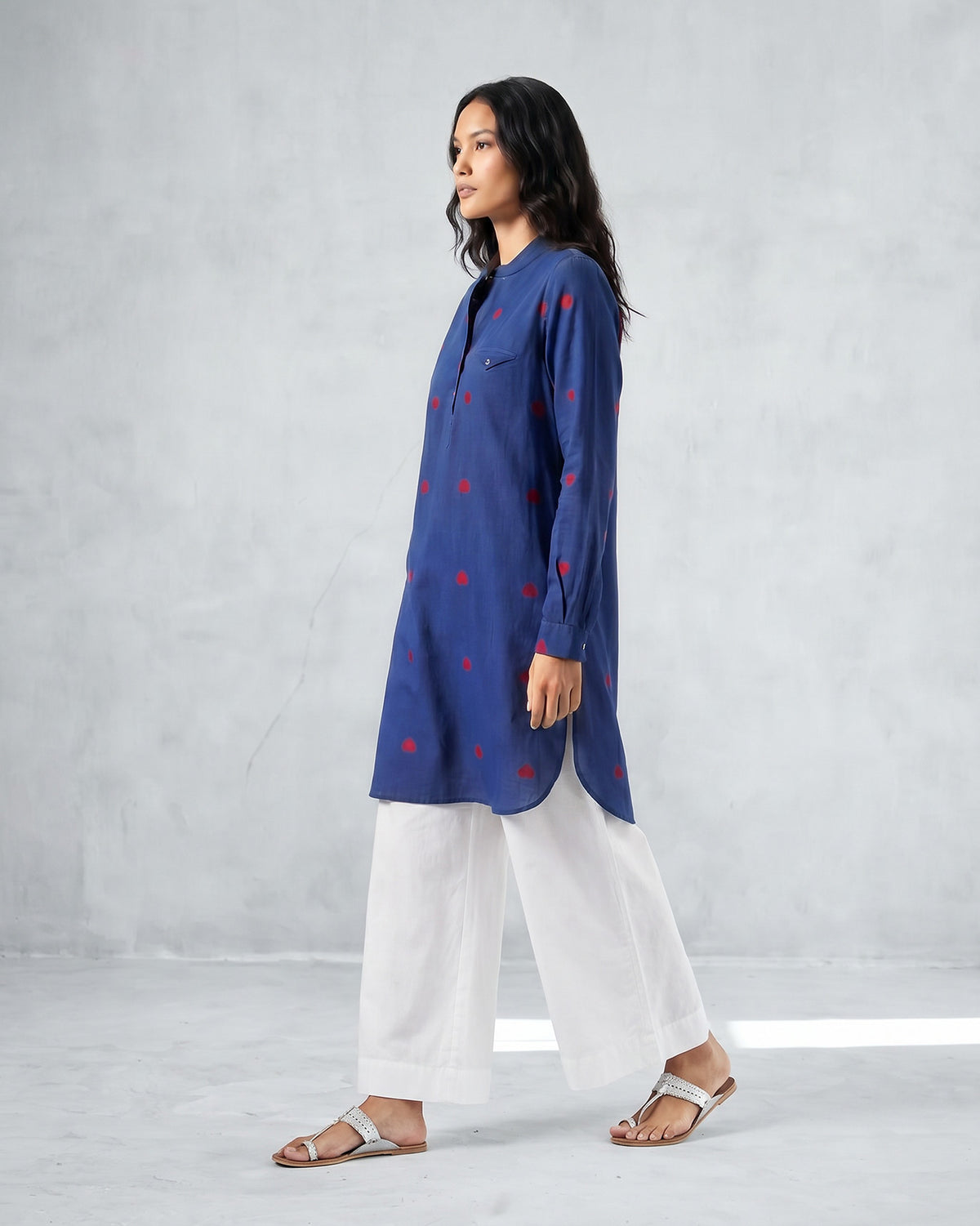 Side view of a navy Fort kurta with red motifs and a curved hem.