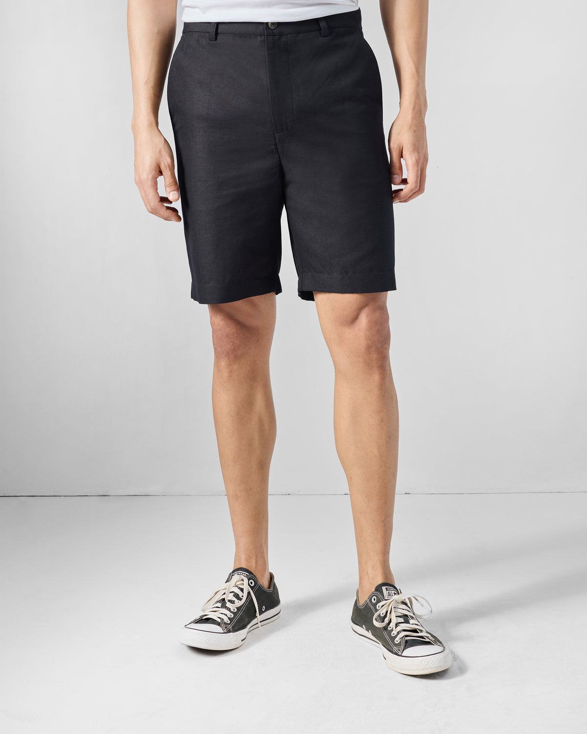 Person wearing black Coast Shorts with a button fly.