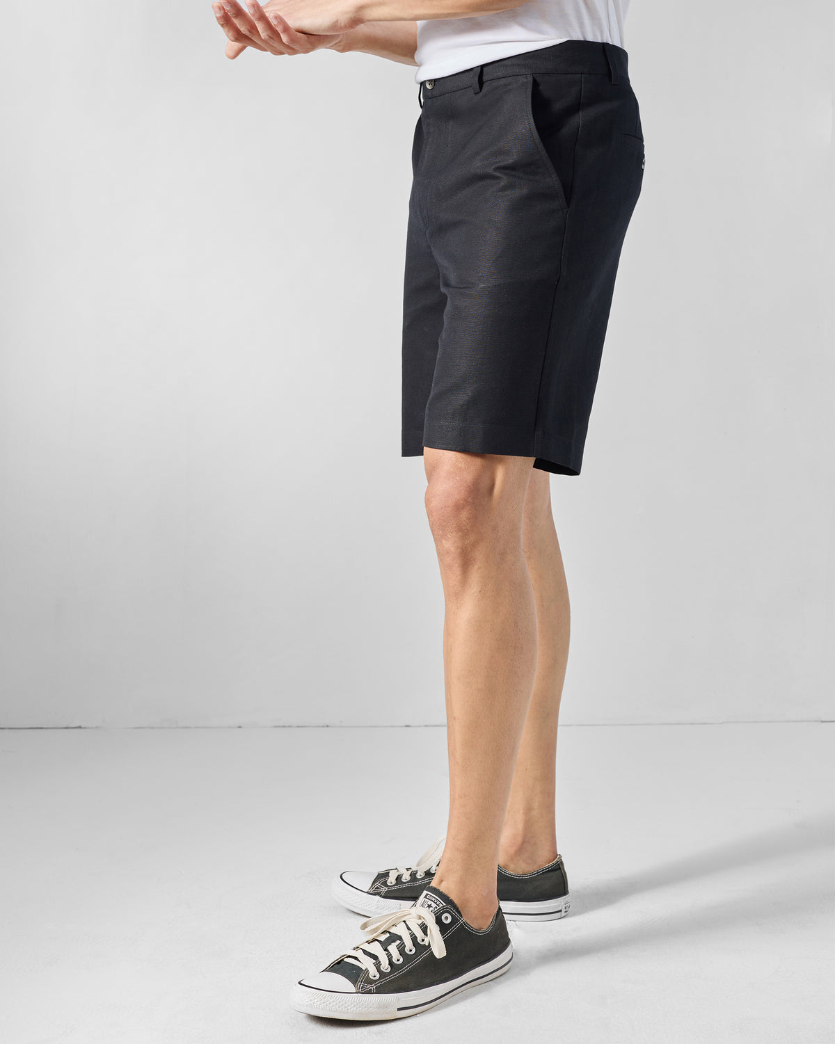 Side view of black Coast Shorts showing their length above the knee.
