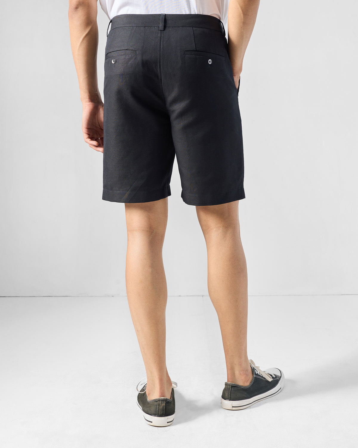 Back of black Coast Shorts worn by a person with two back pockets.