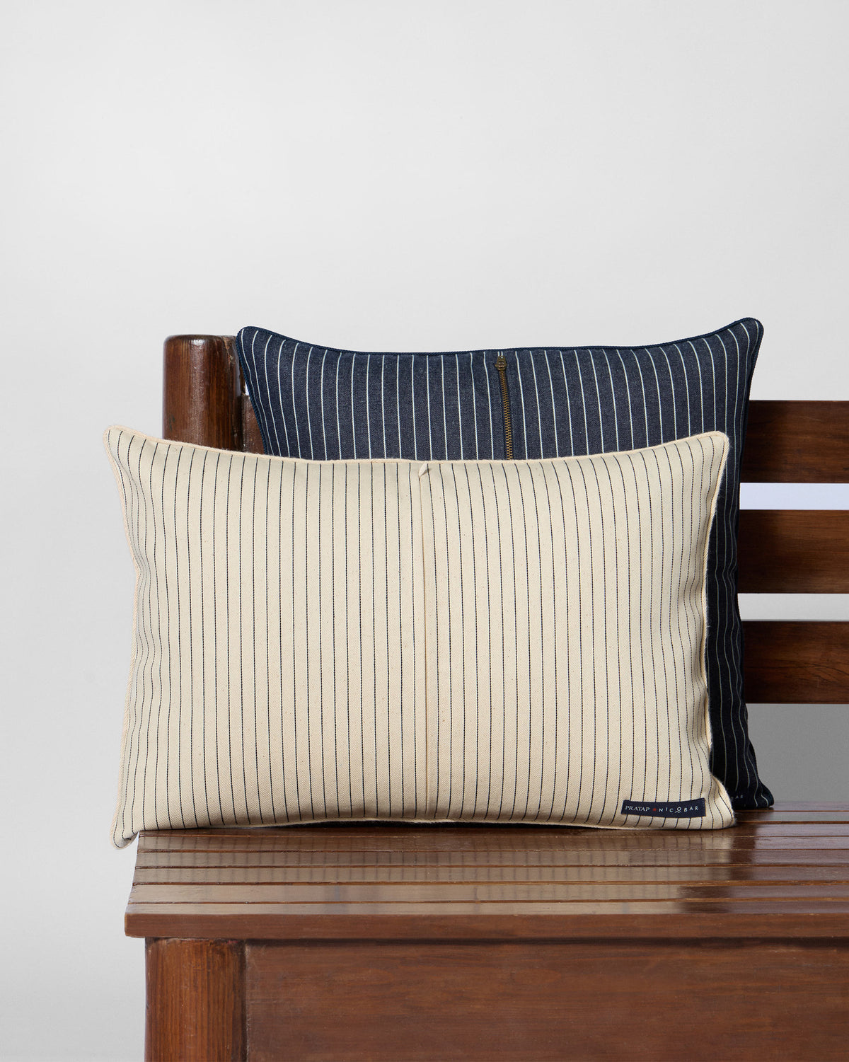 Reverse of a Guldaudi lumbar cushion with cream and navy pinstripes.