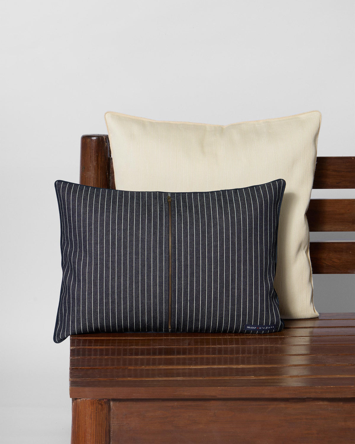 Back of a navy pinstriped Neelakurinji lumbar cushion with a central zip.