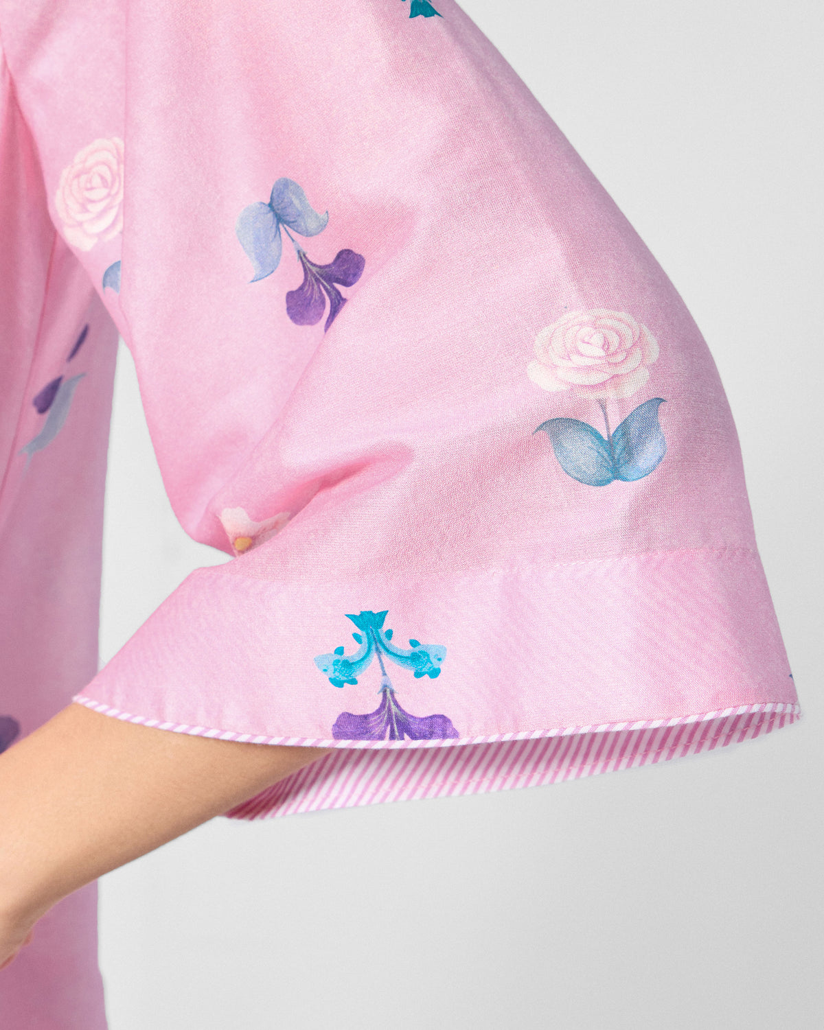 Close-up of a soft pink Hera Kurta sleeve with floral print and striped cuff lining.