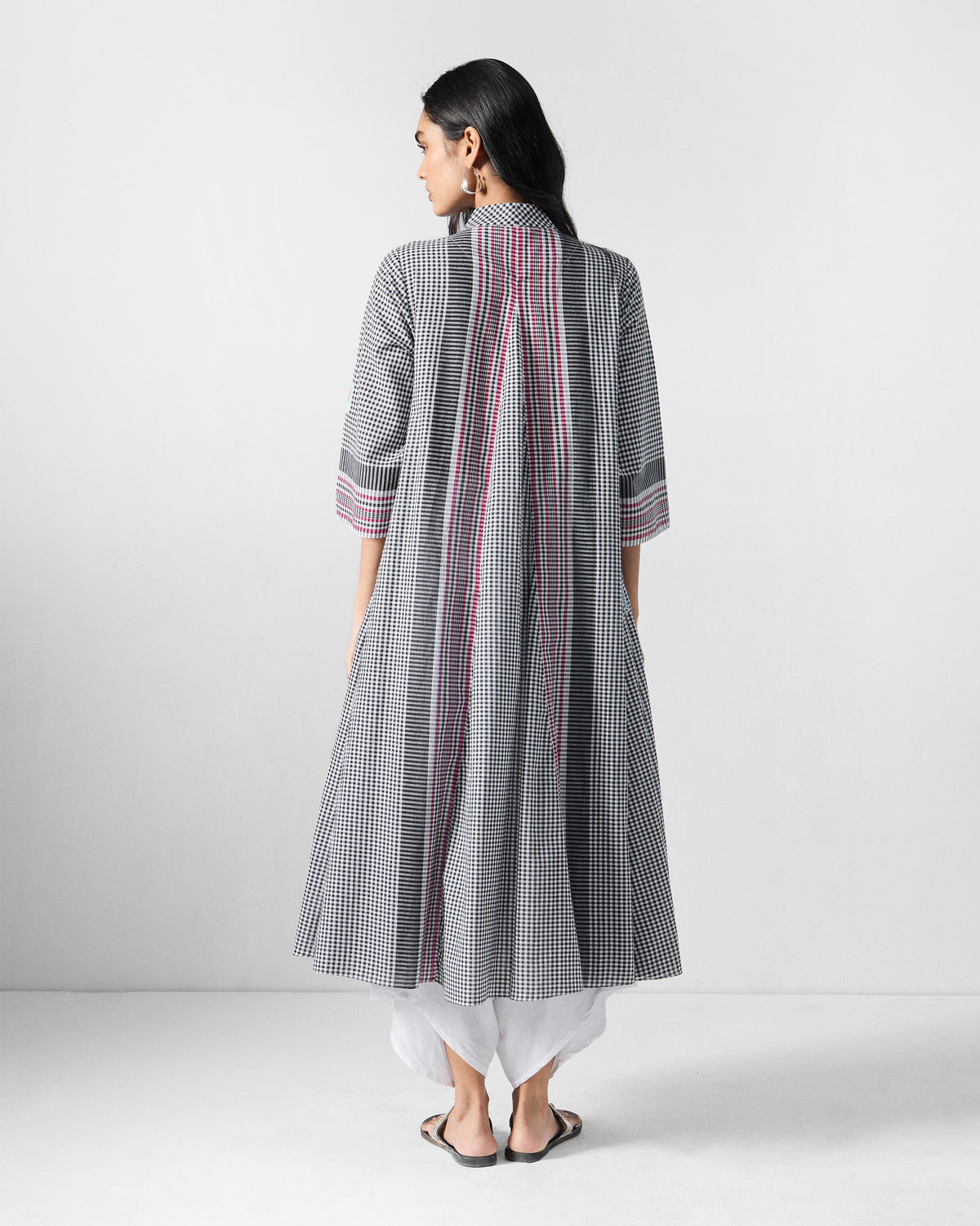Back of a black and white checked Leah kurta with red stripe panels and a deep pleat.