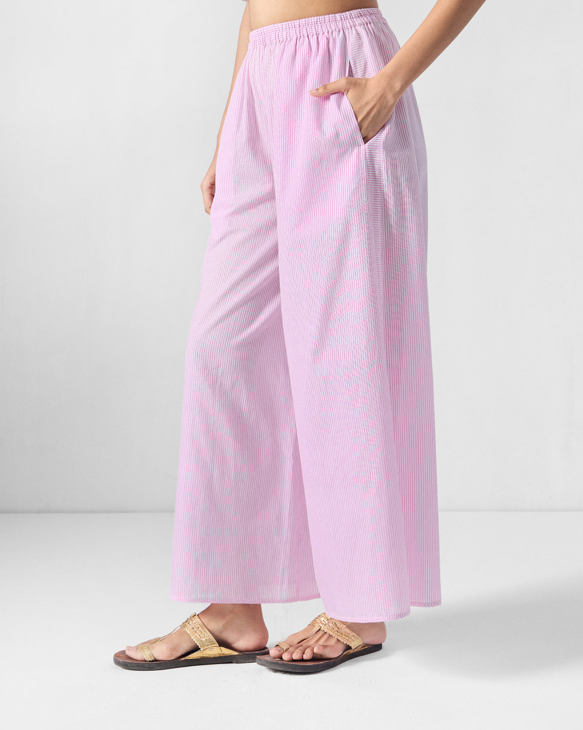 Angled view of pink and white striped Ceylon pants with a wide-leg cut.