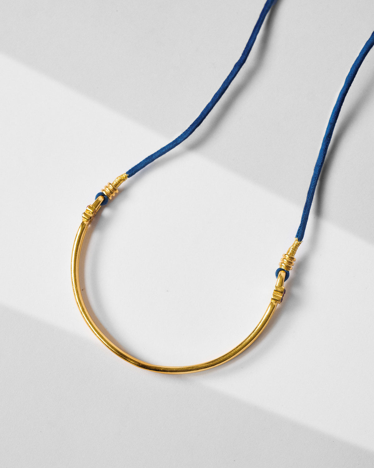 Gold baju bandh arc joined to a cobalt blue cord.