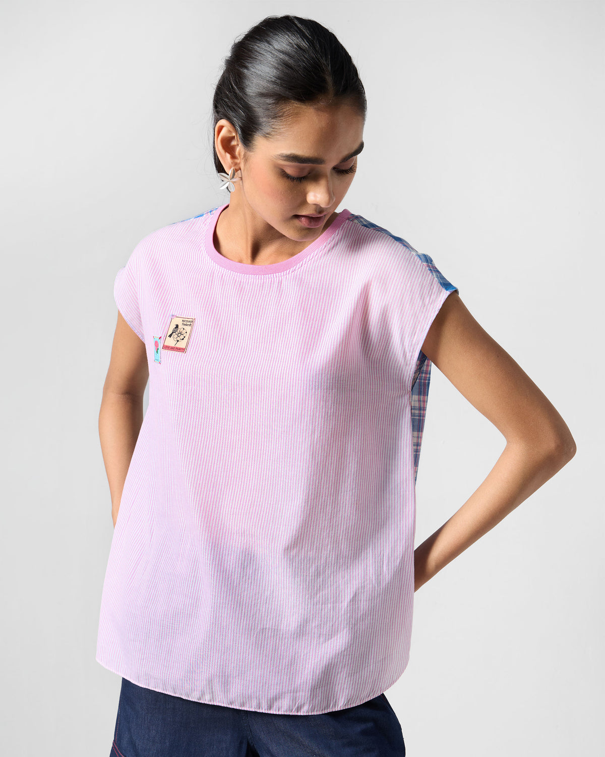Person wearing a multicolour Faye top with pink stripes and check sleeves.
