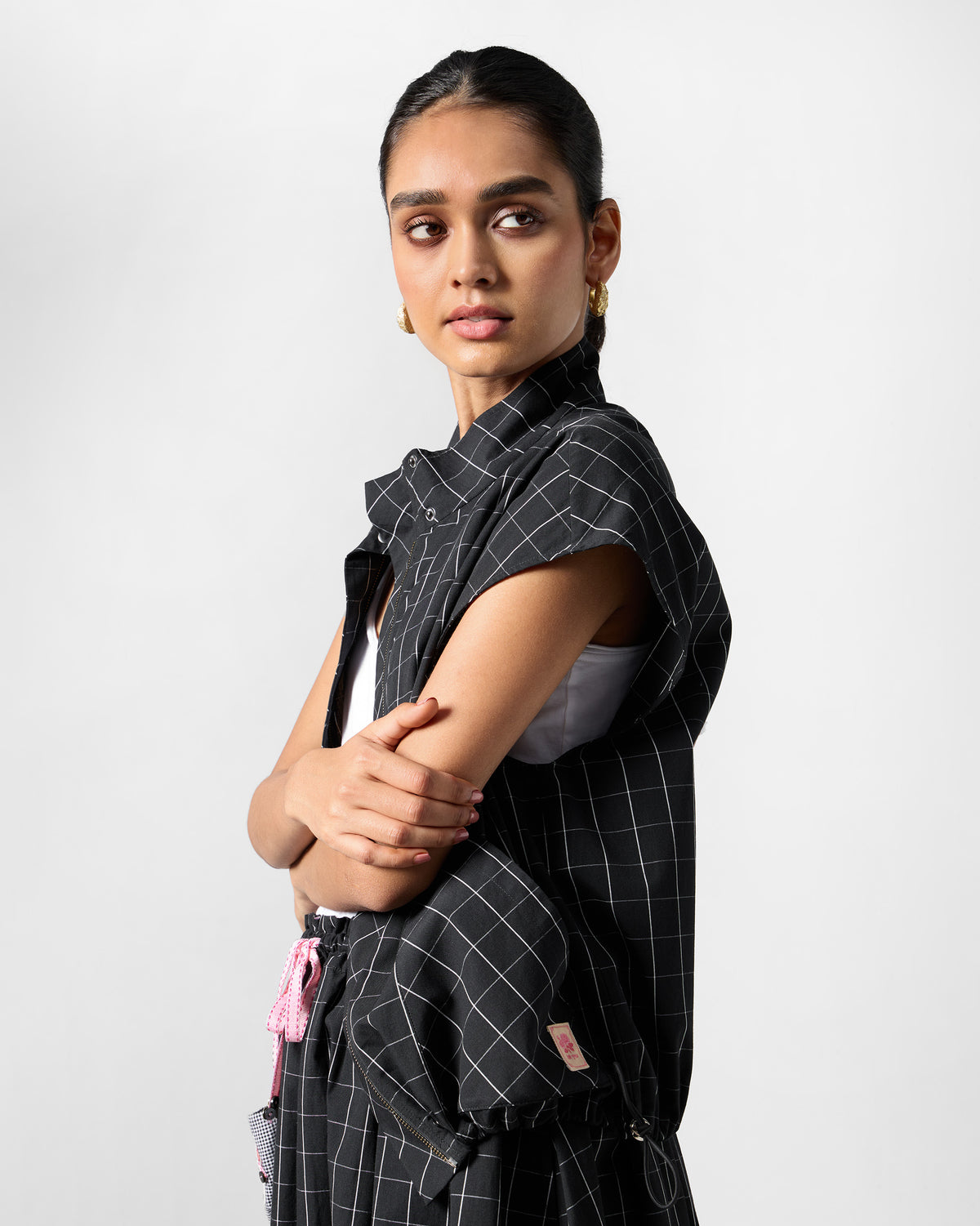 Side profile of a black-and-white checked Renai top worn open over a white tank.