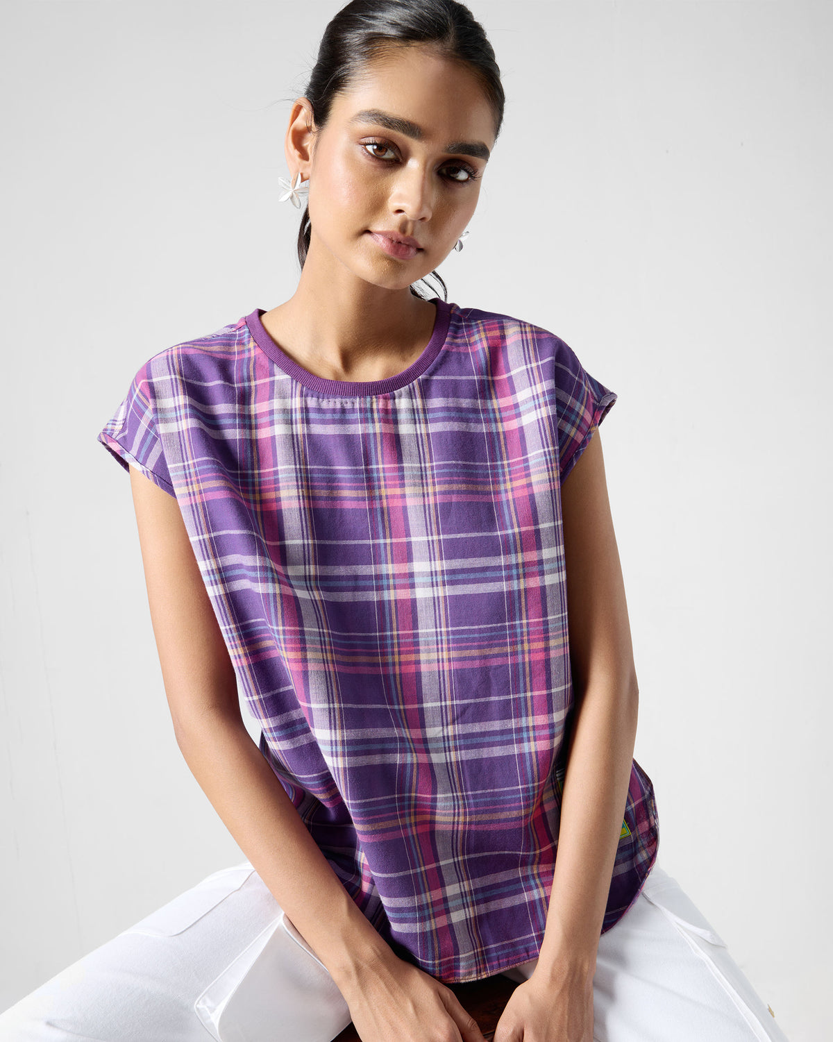Person wearing a short-sleeve purple plaid Flow top.