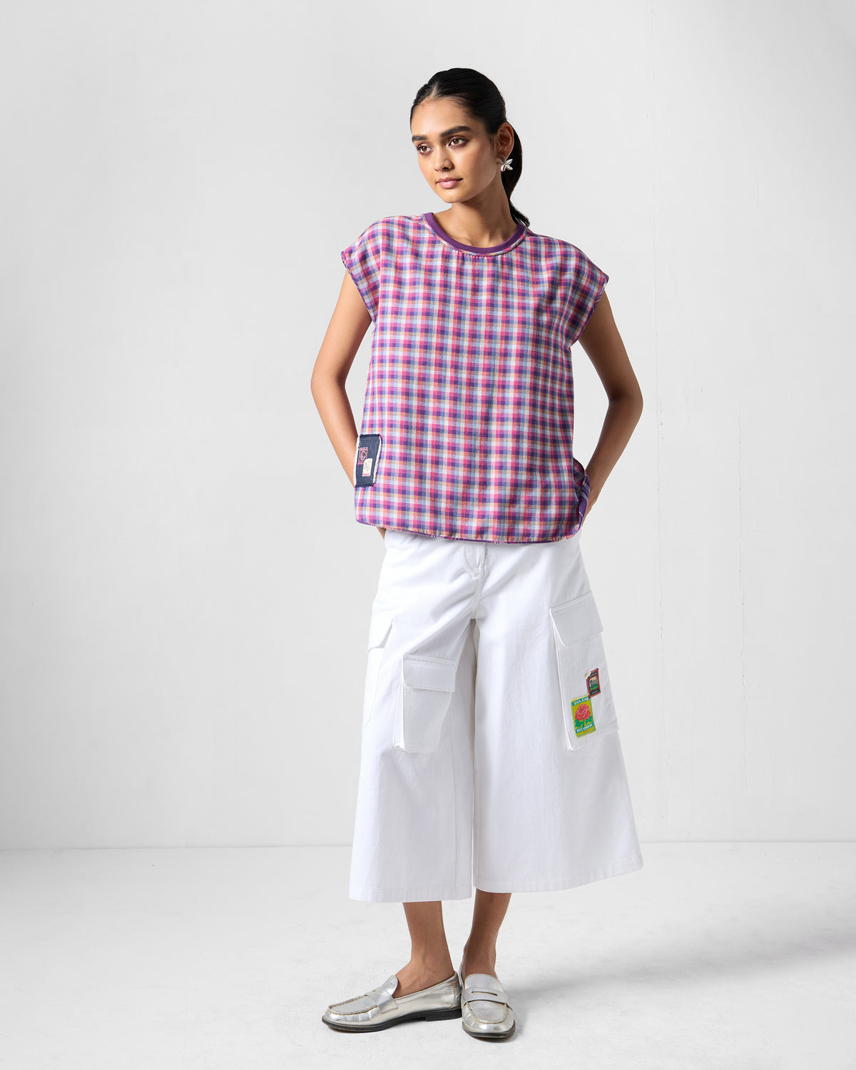 Person wearing a purple check Flow top with a dark hem patch.