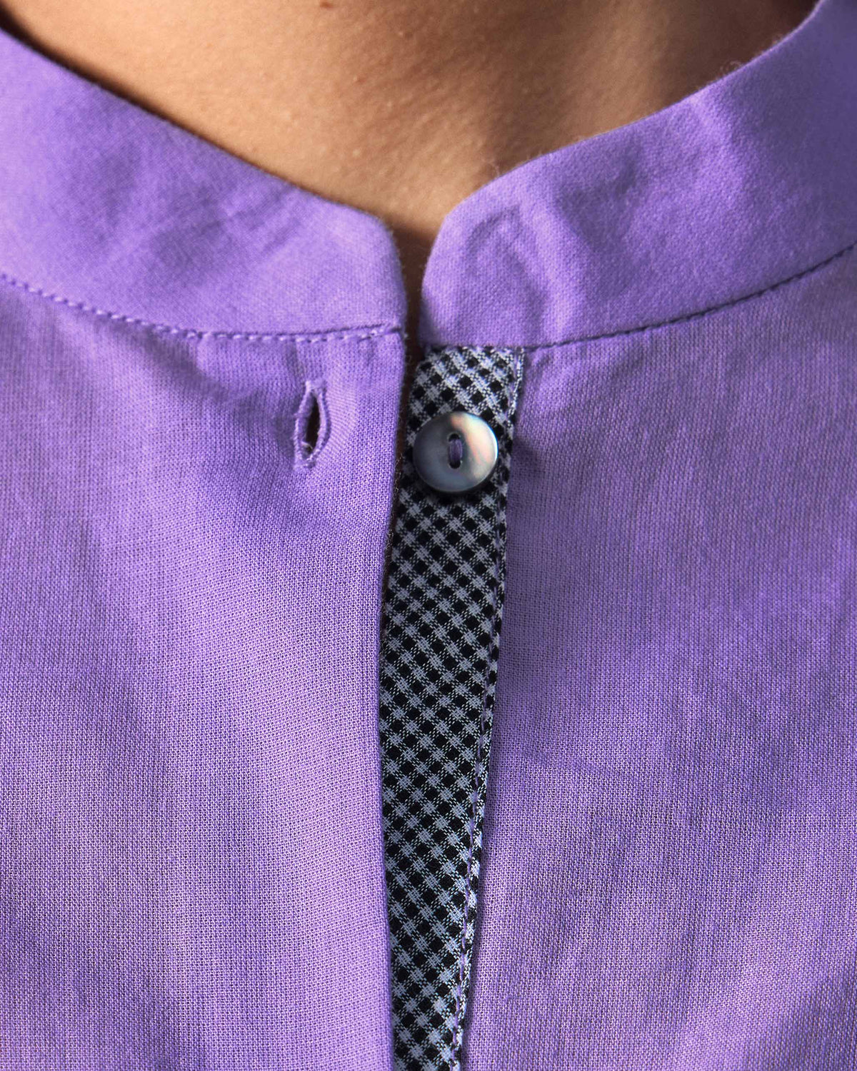 Close-up of a black-and-white checkered placket inside a lilac kurta.