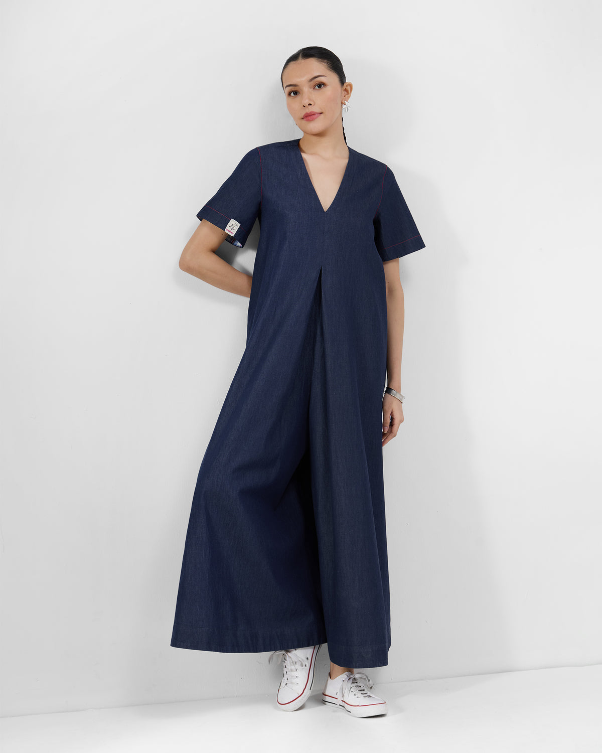 Person wearing a navy Peru jumpsuit with a V-neck and wide legs.