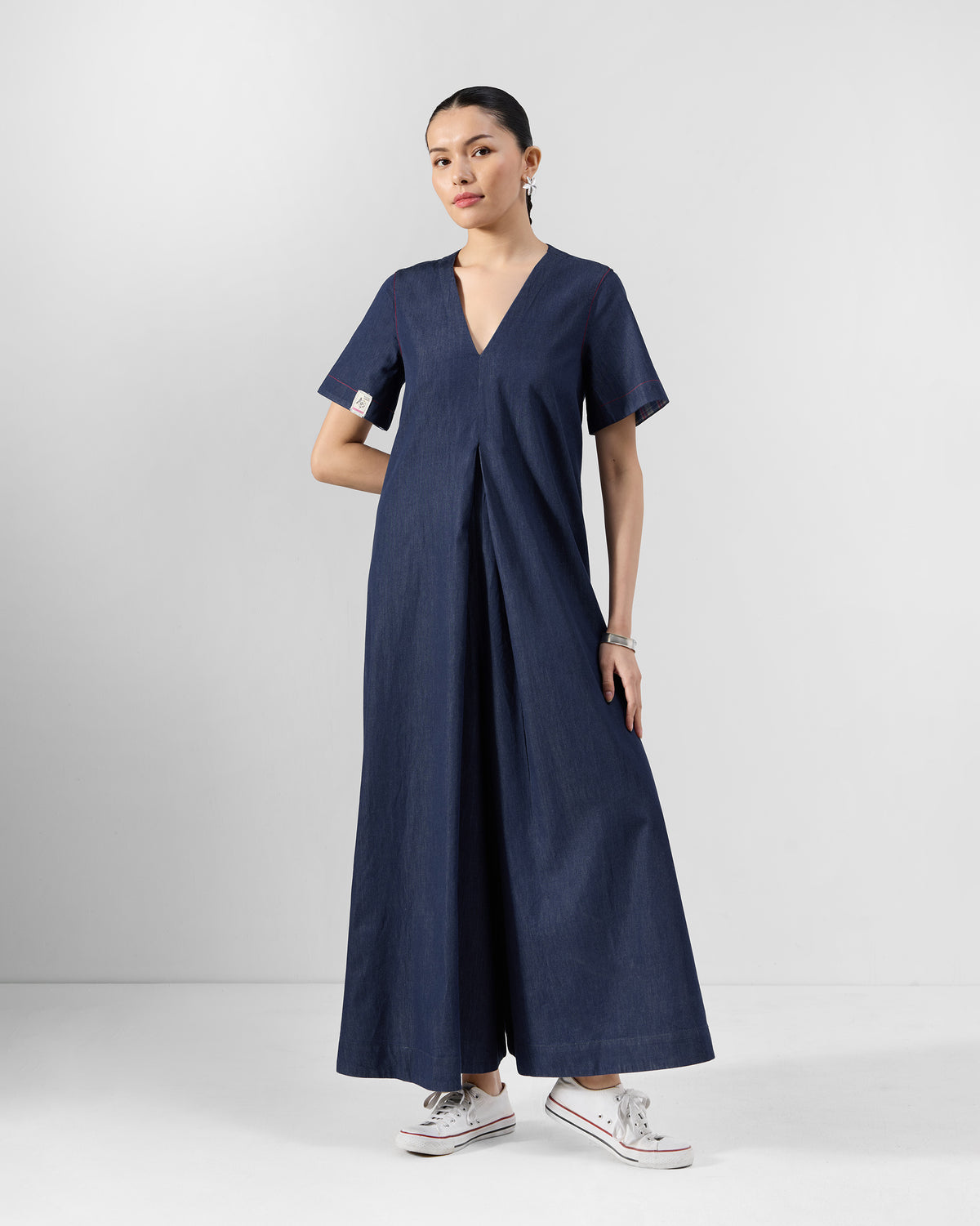 Three-quarter view of a navy Peru jumpsuit with short sleeves and wide legs.