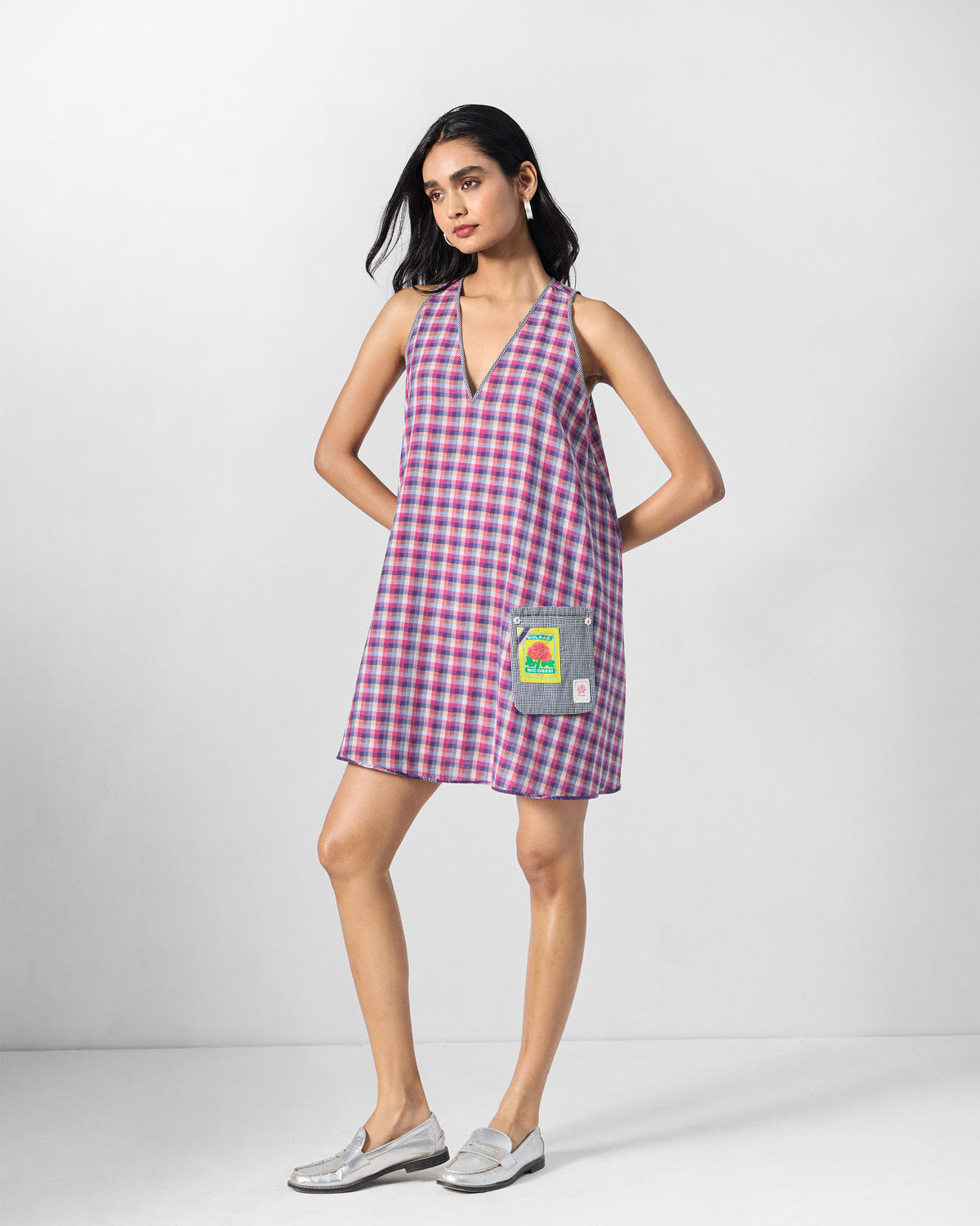 Person wearing the reverse of a Daye dress with a rose patch pocket.