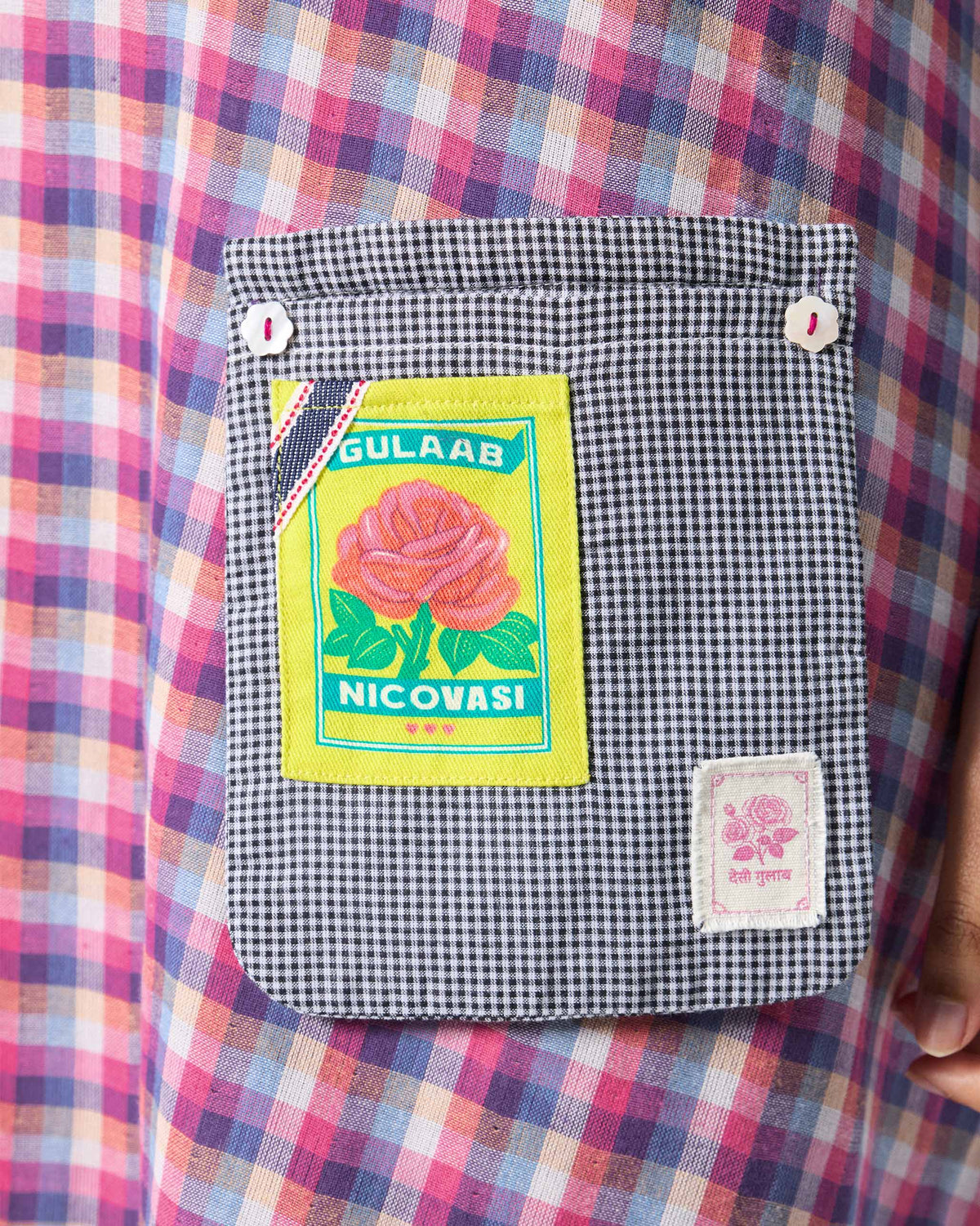 Close-up of a Daye dress pocket with a rose patch and flower buttons.