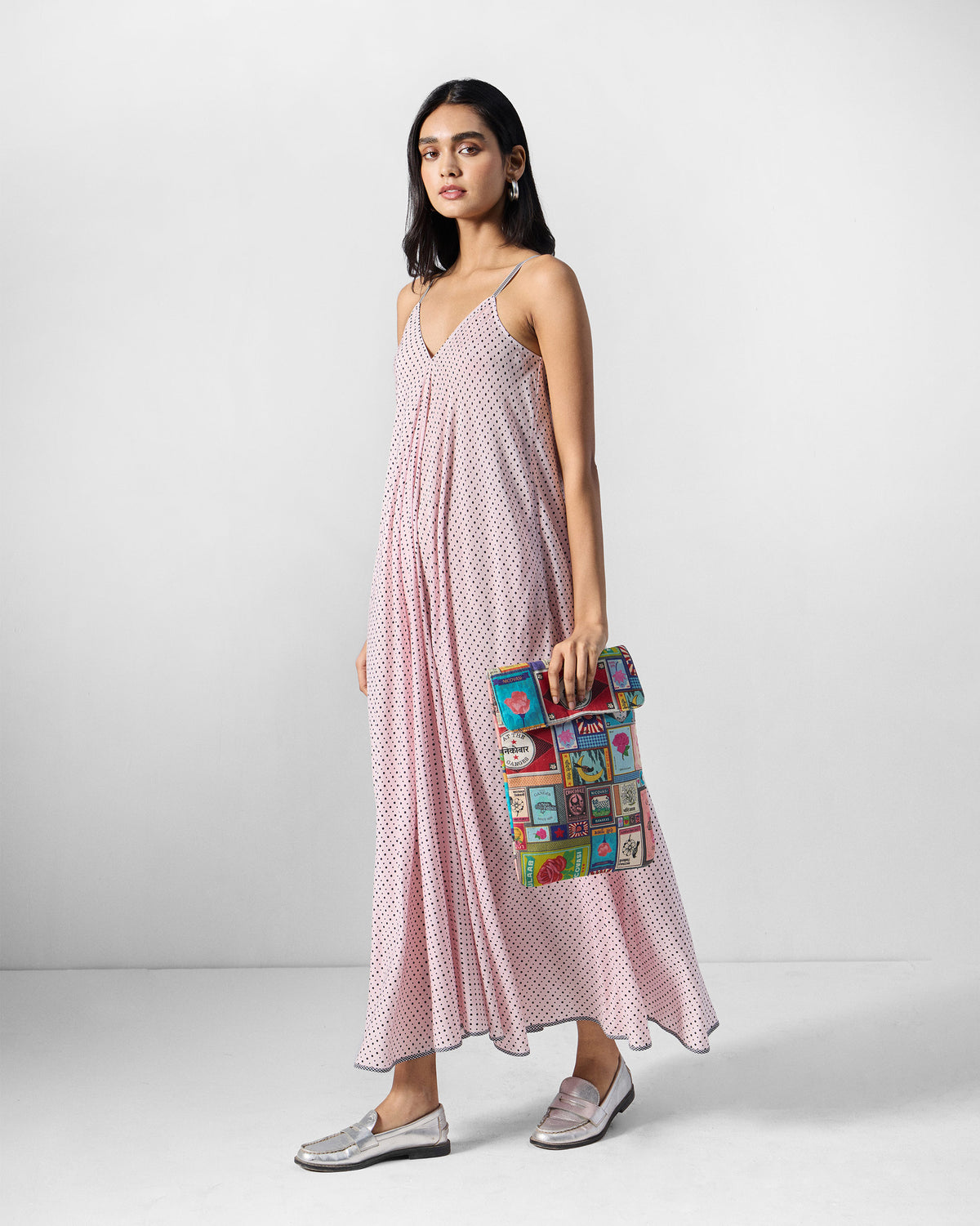 Person wearing a pink and charcoal printed V-neck strappy dress.