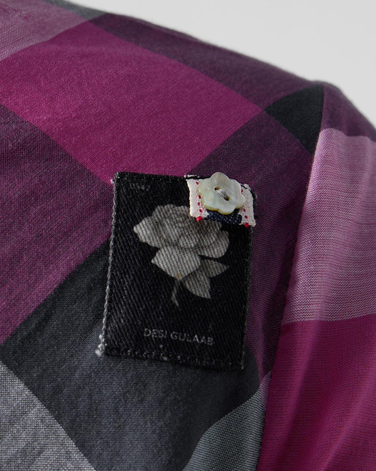 Close-up of a Desi Gulaab rose patch on a multicolour check Areva A-Line Dress.
