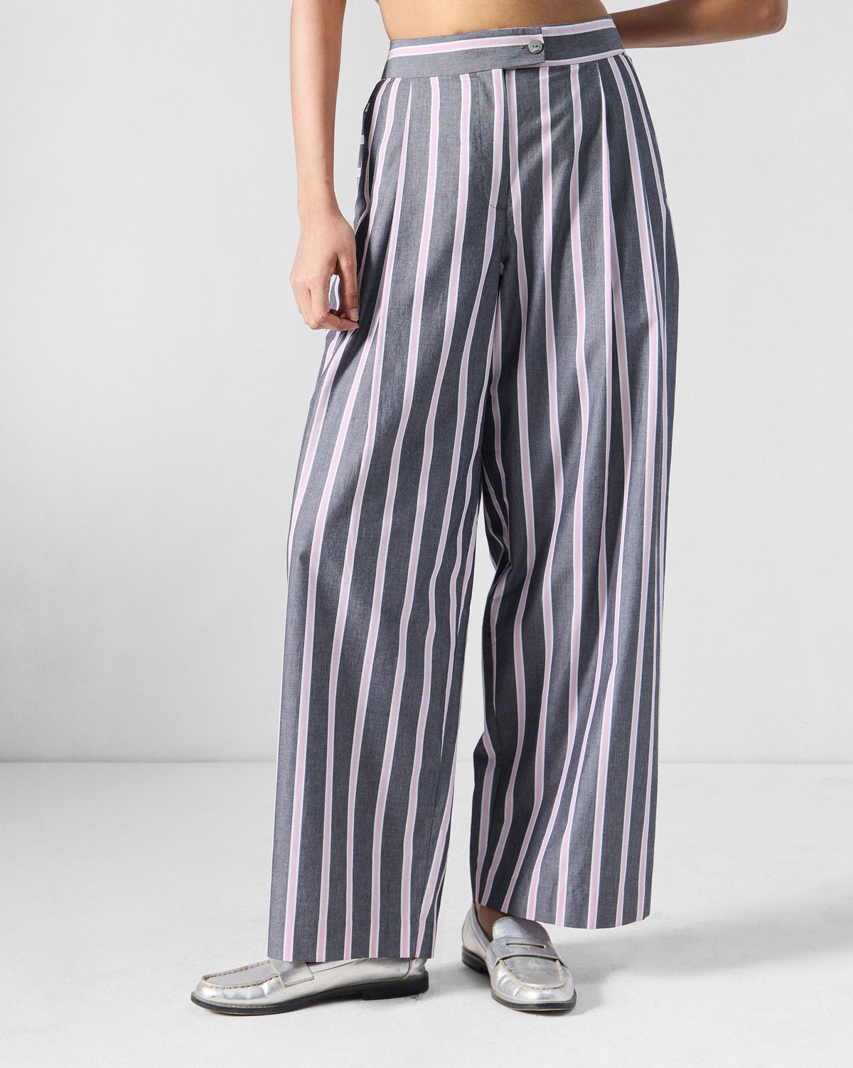Person wearing charcoal and pink striped Row high waist pants.