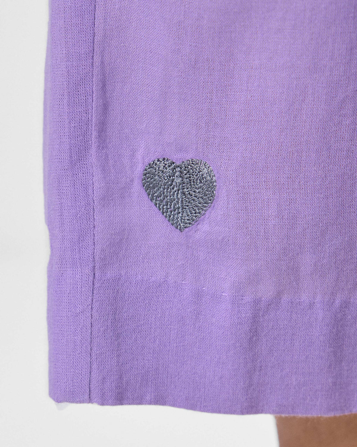 Close-up of a silver embroidered heart near the hem of lilac Kinatra Pants.