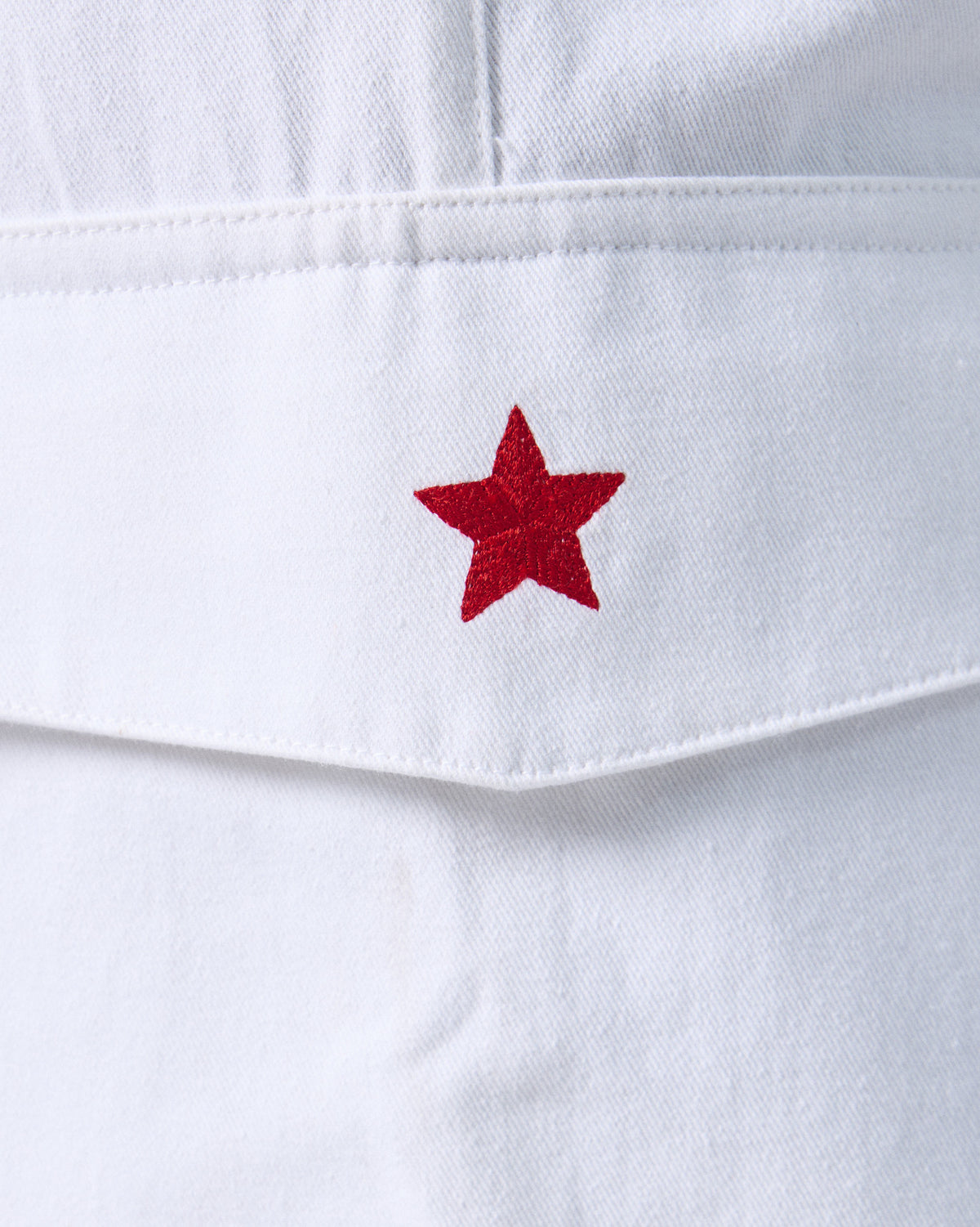 Close-up of a red embroidered star on white Ella culottes.