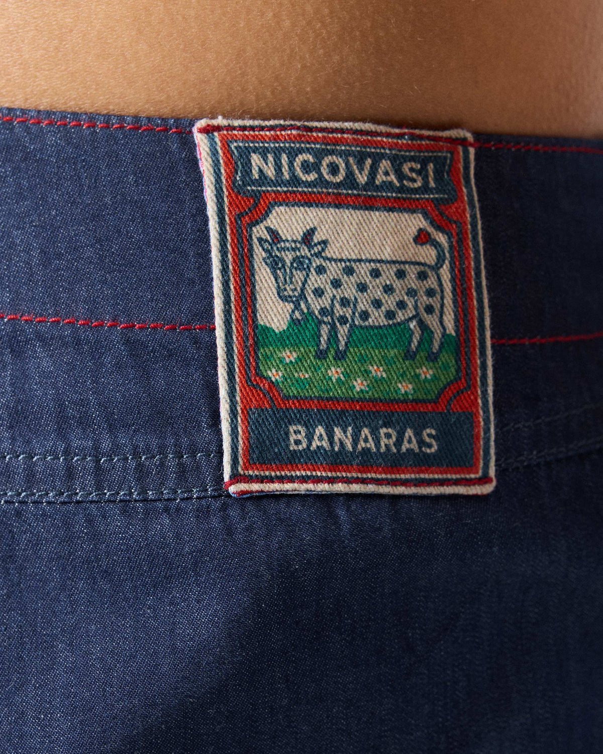 Close-up of the Banaras cow label on the back waistband of blue Ella culottes.